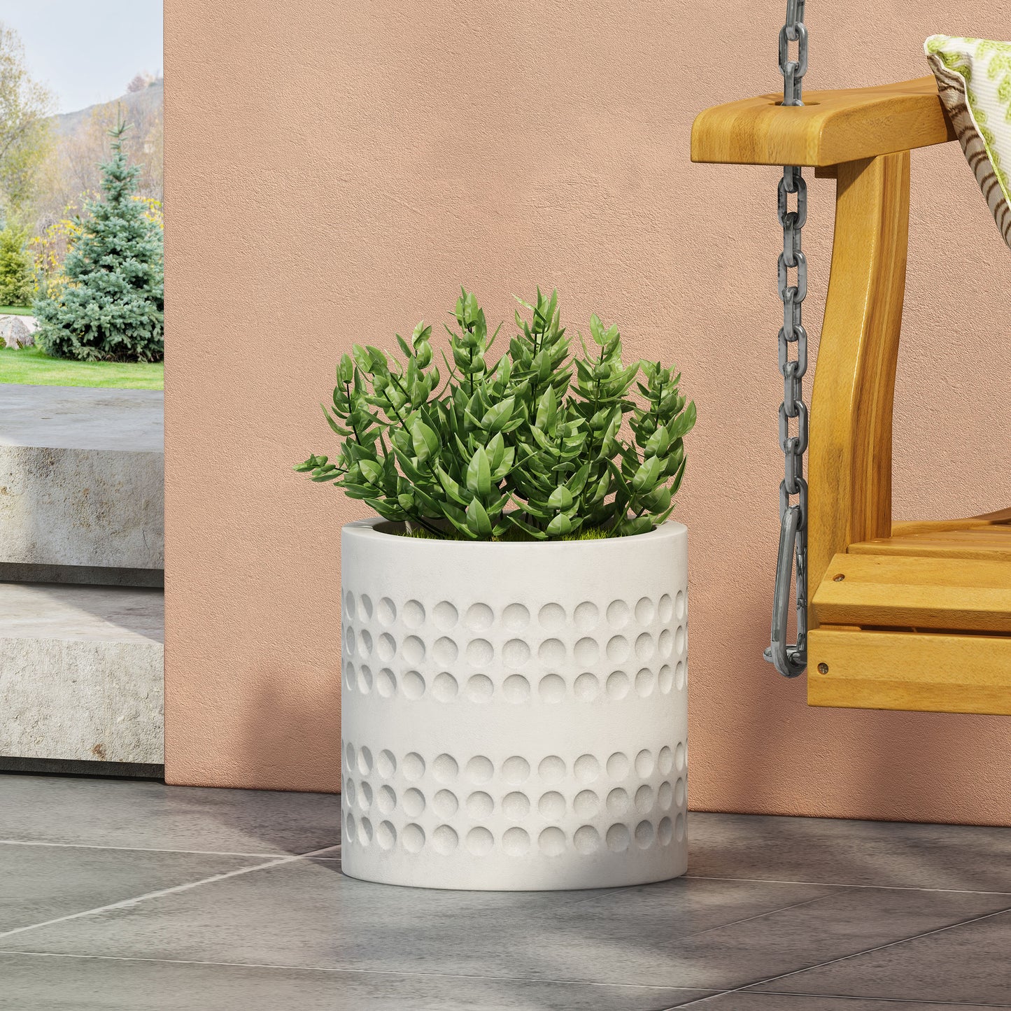White textured ceramic planter with a dimpled design holding a lush green plant