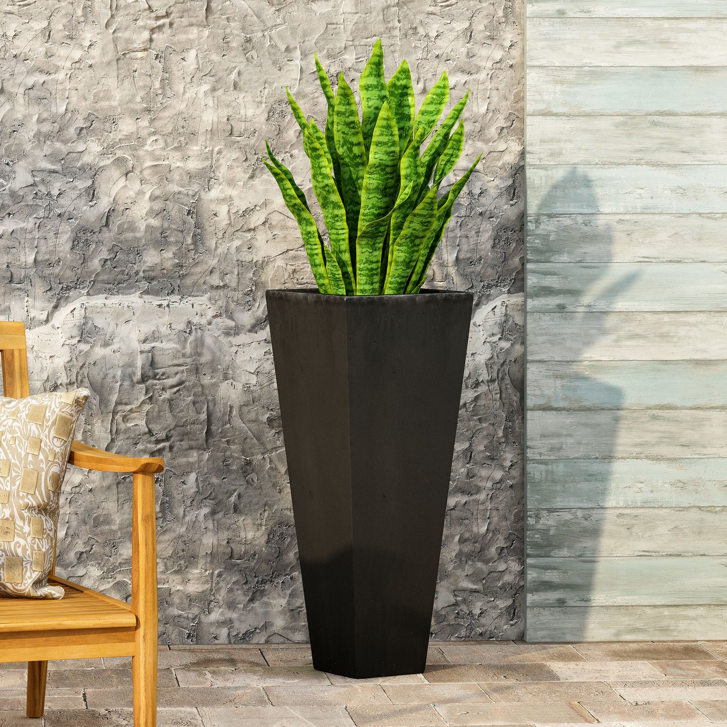 Tall black fiberglass planter with vibrant green snake plant perfect for modern outdoor decor