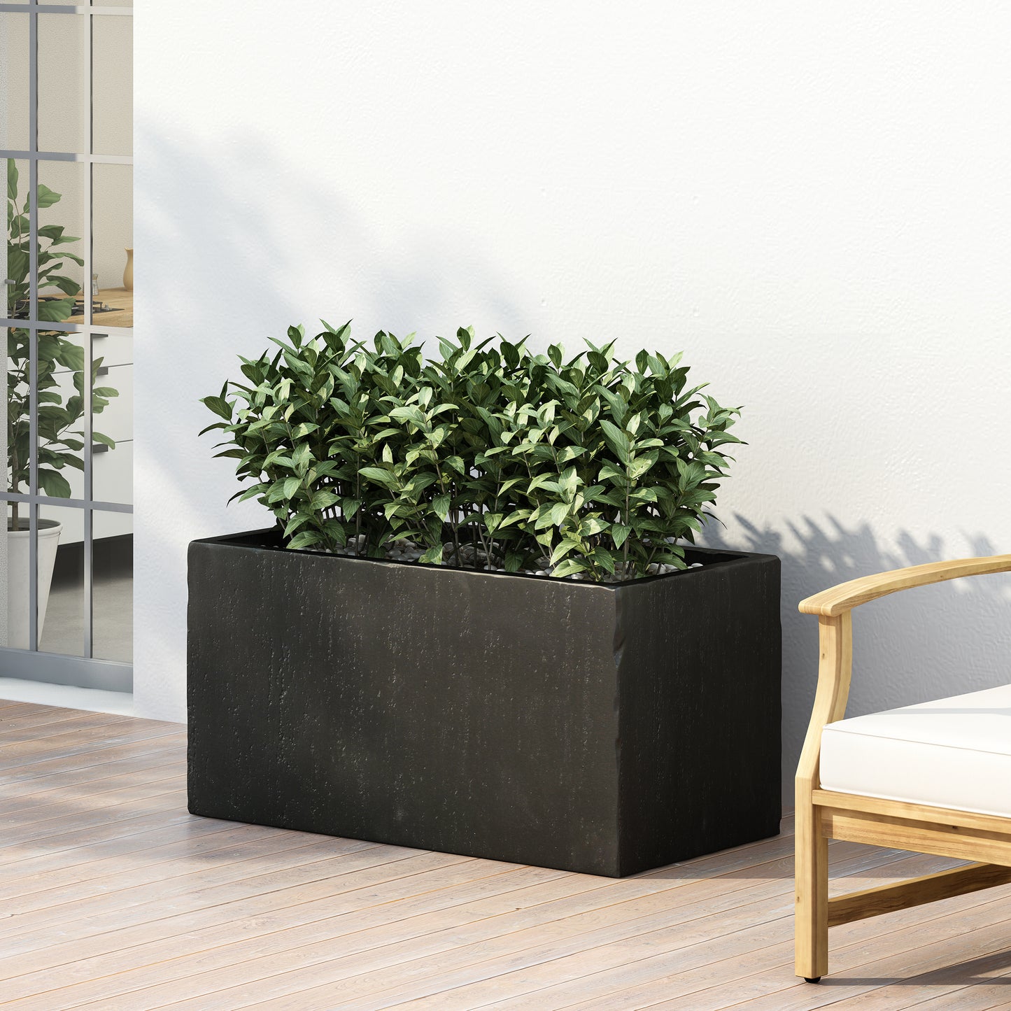 Rectangular black textured planter with lush green plants on a modern patio