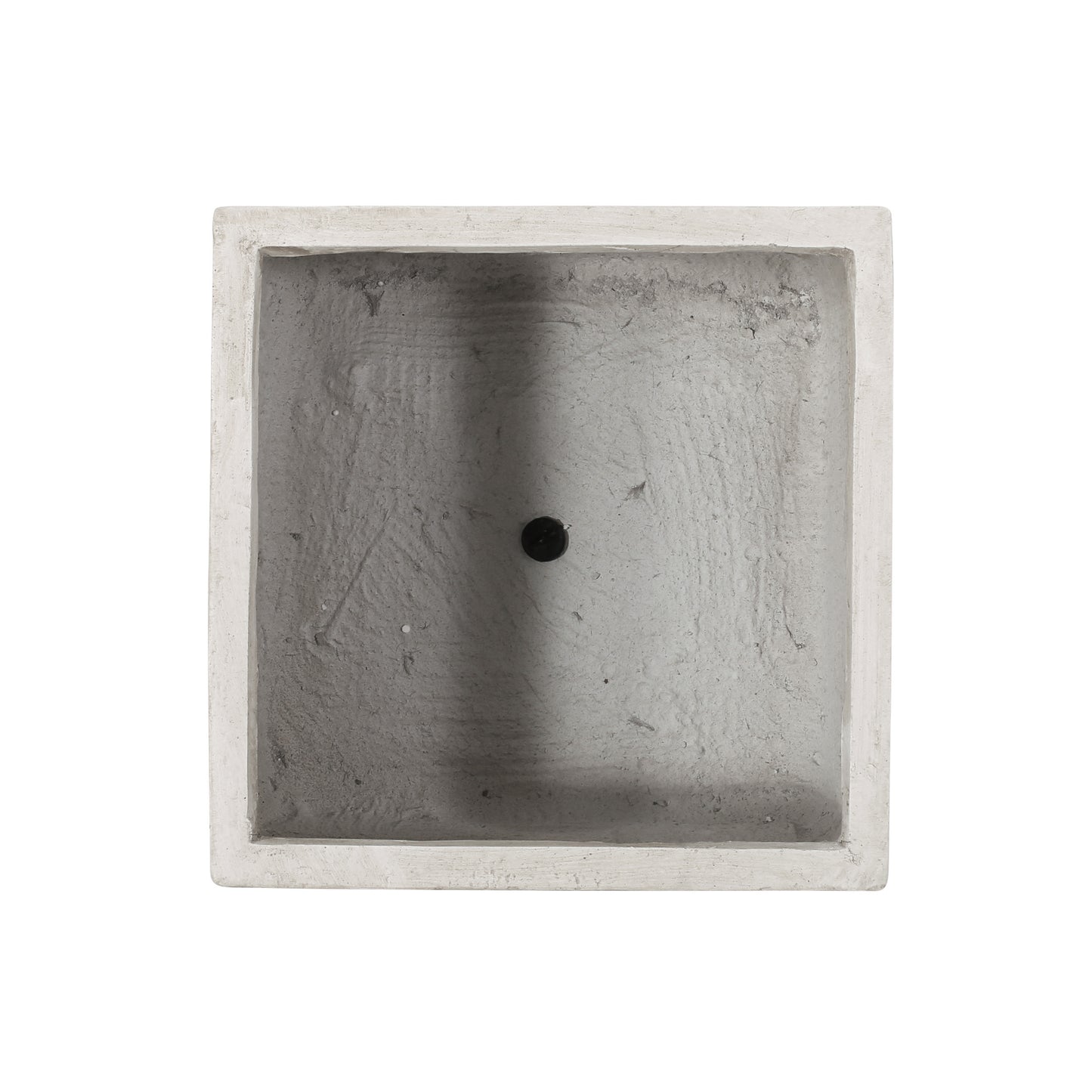 Top view of a square concrete planter with a drainage hole