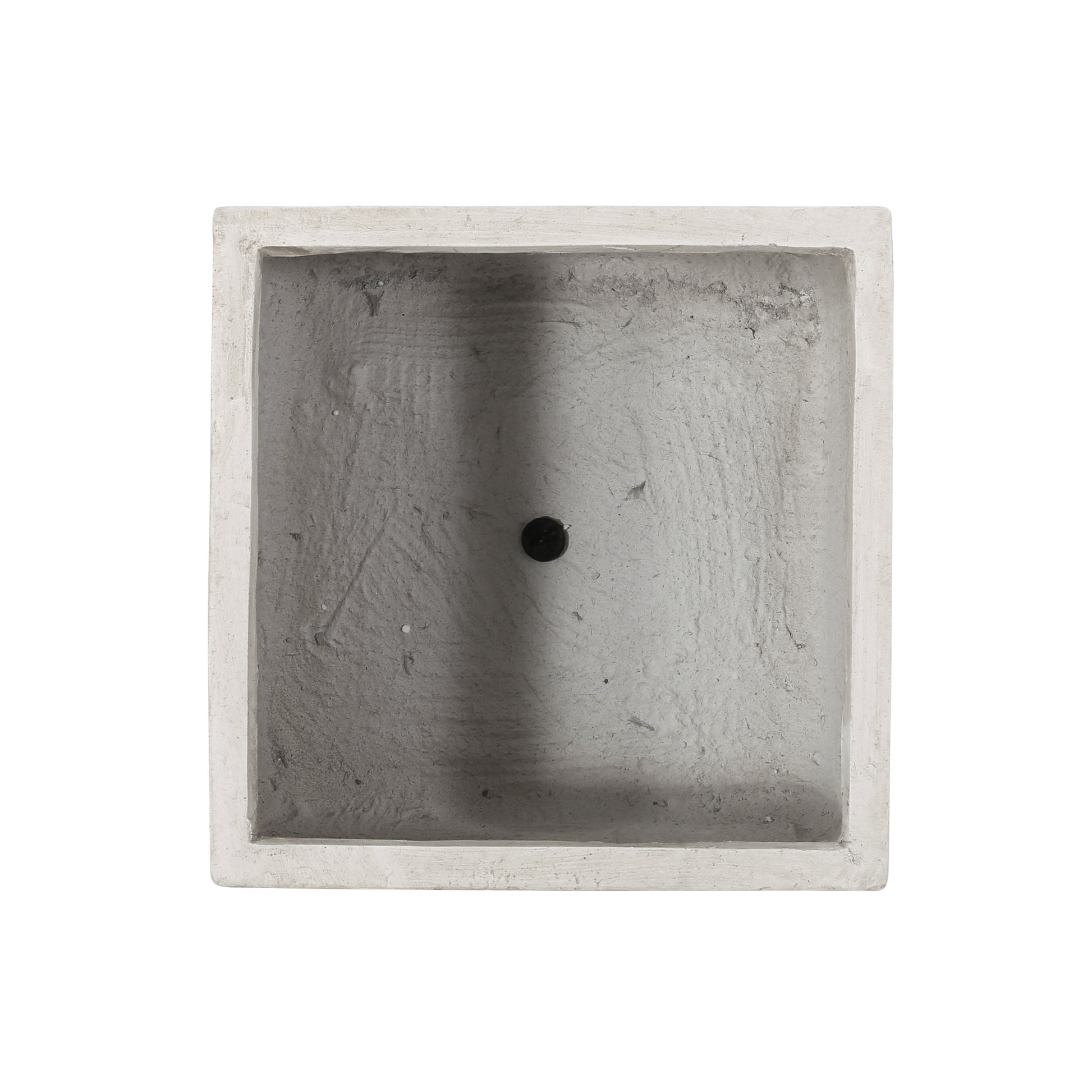 Top view of a square concrete planter with a drainage hole