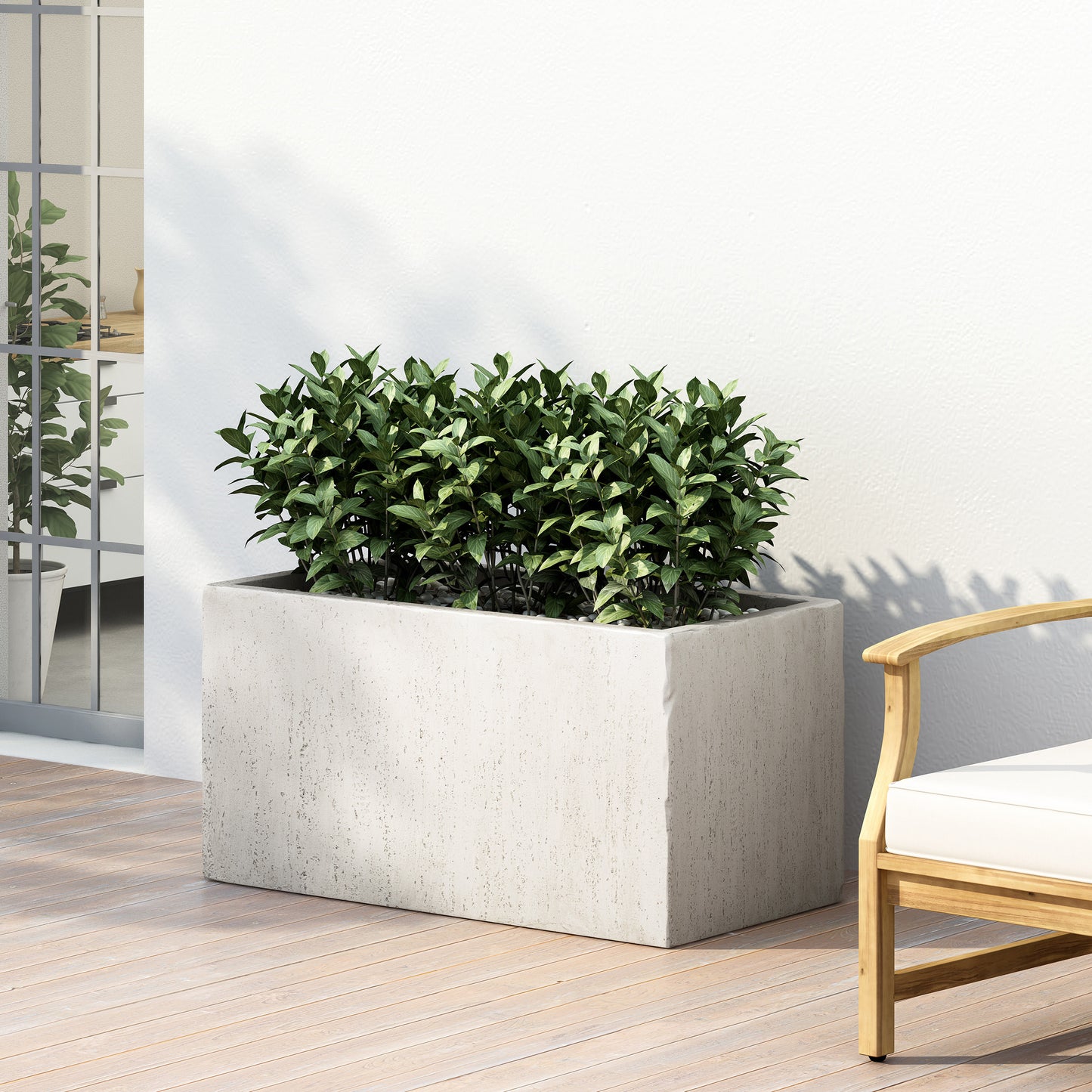 Rectangular concrete planter with dense green foliage and white pebbles