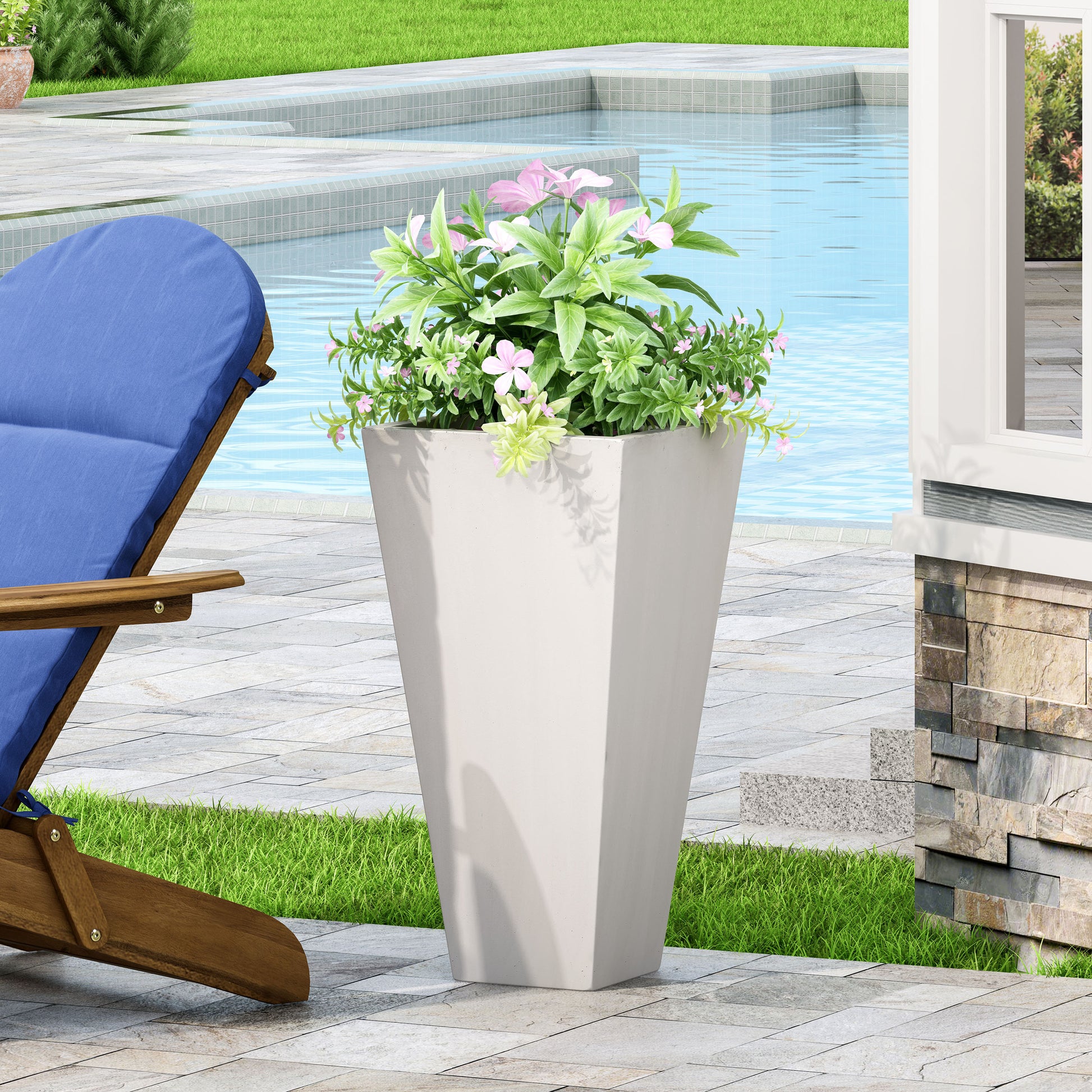 Tall concrete planter with pink flowers and green foliage on patio near pool