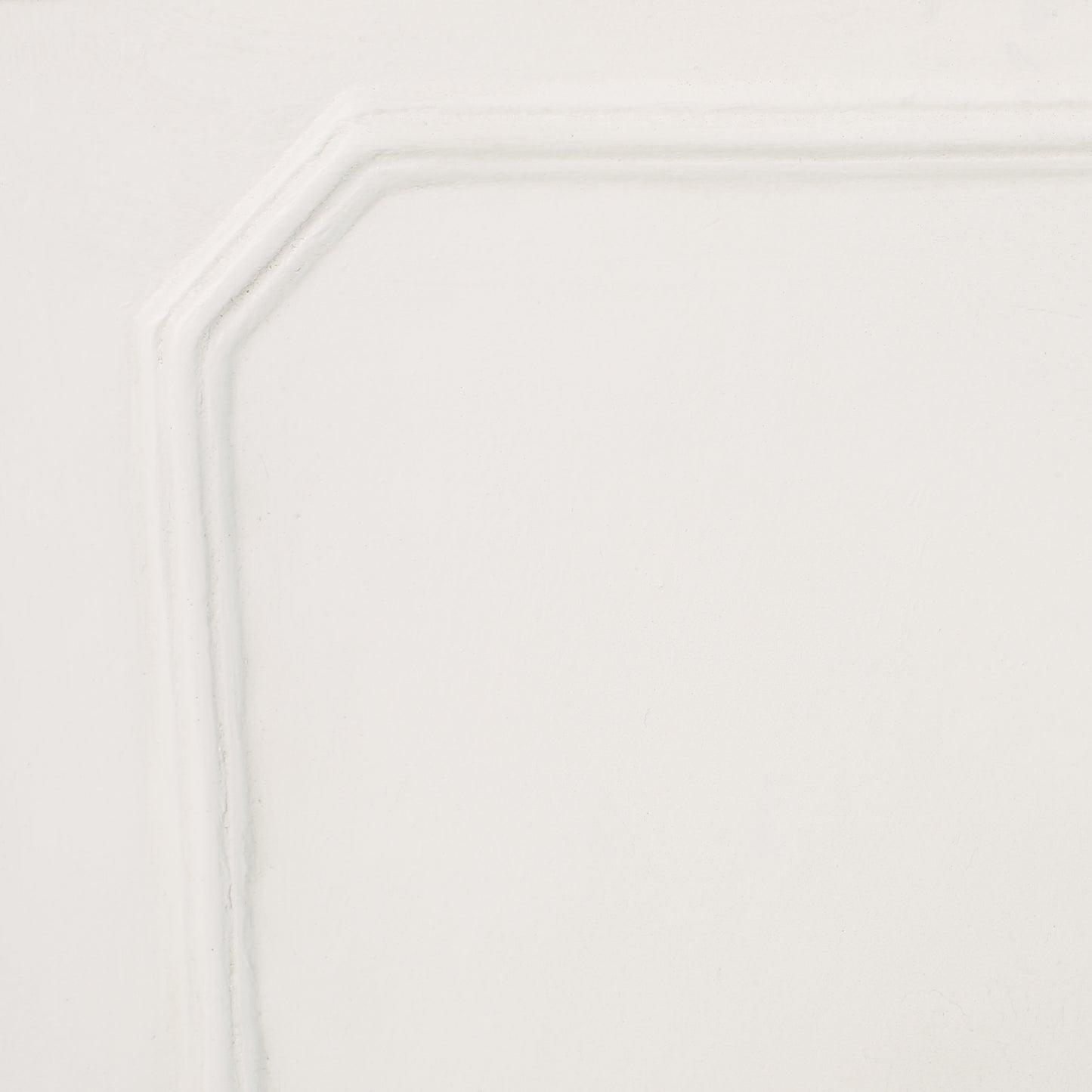 Close up of a white paneled cabinet door with raised molding details