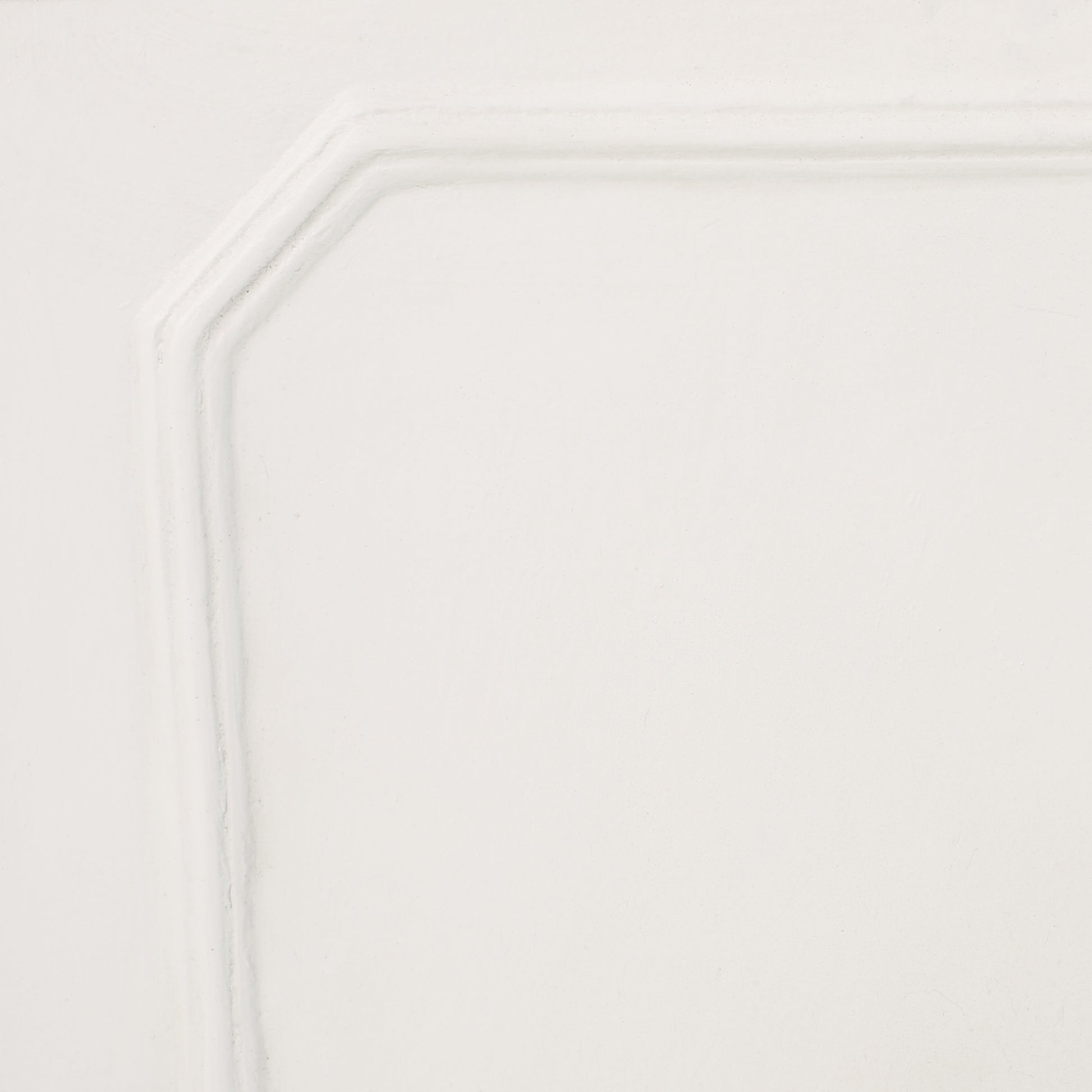 Close up of a white paneled cabinet door with raised molding details