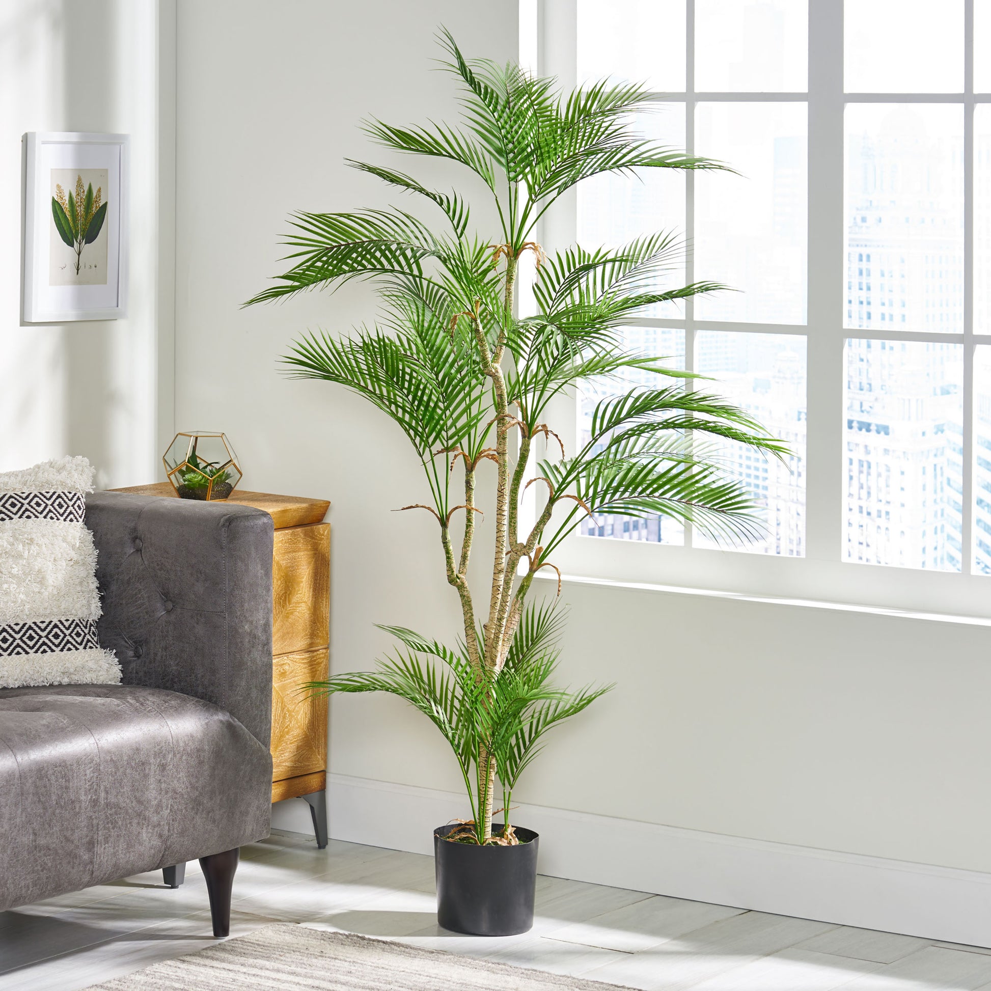 Tall artificial palm tree with lush green fronds in a black planter perfect for living room decor