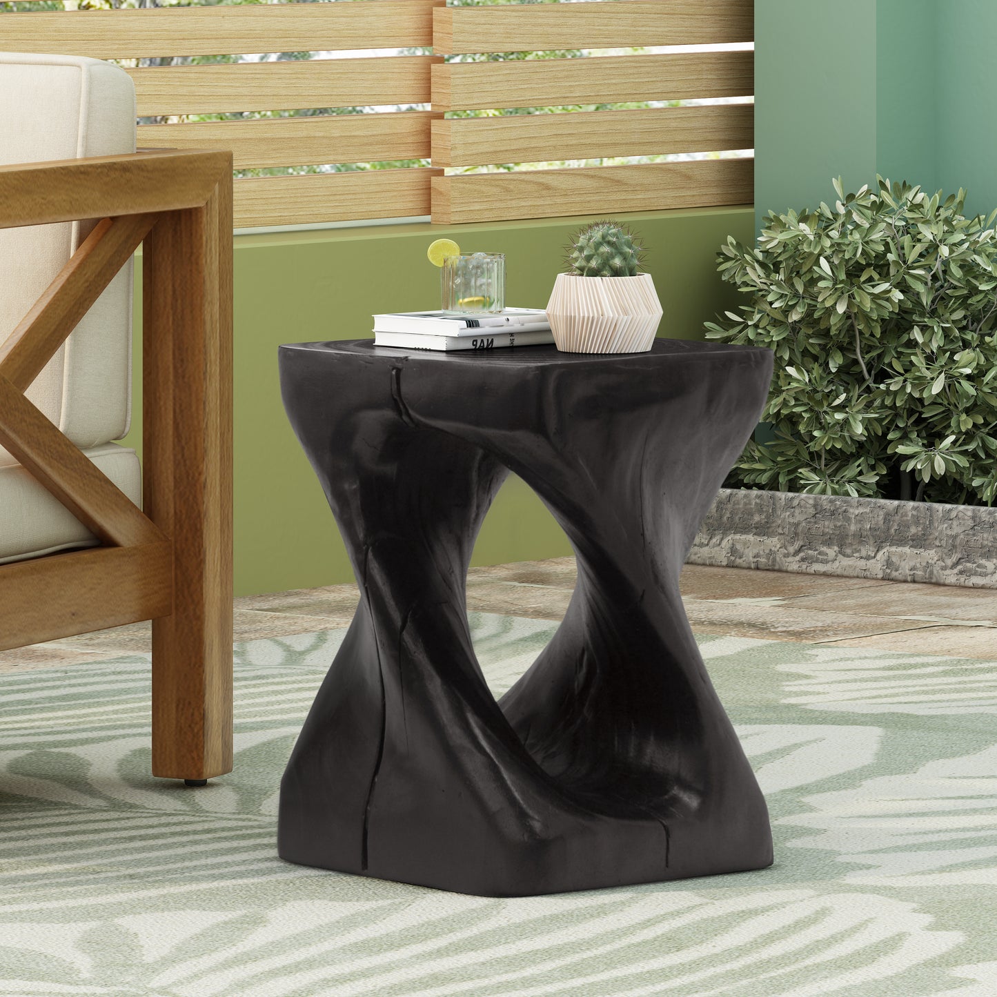 Black twisted wood garden accent table with books and cactus