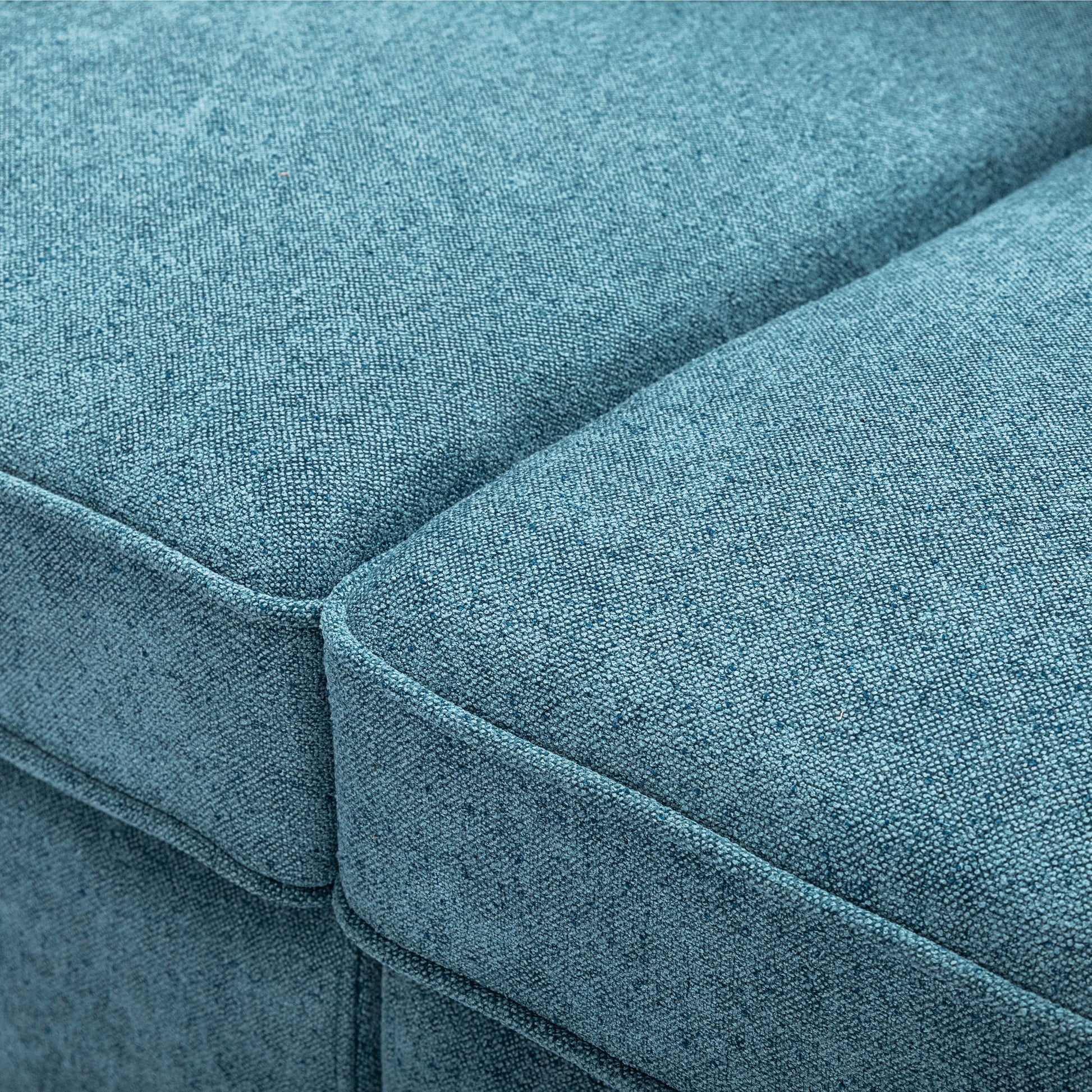 Closeup of a textured teal fabric sofa cushion with visible weave for comfort