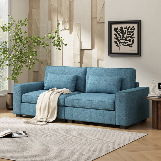Teal fabric sofa with throw blanket and two accent pillows on hardwood floor