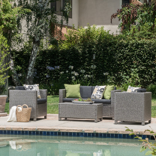 Gray wicker outdoor sofa set with green and floral cushions on patio by pool
