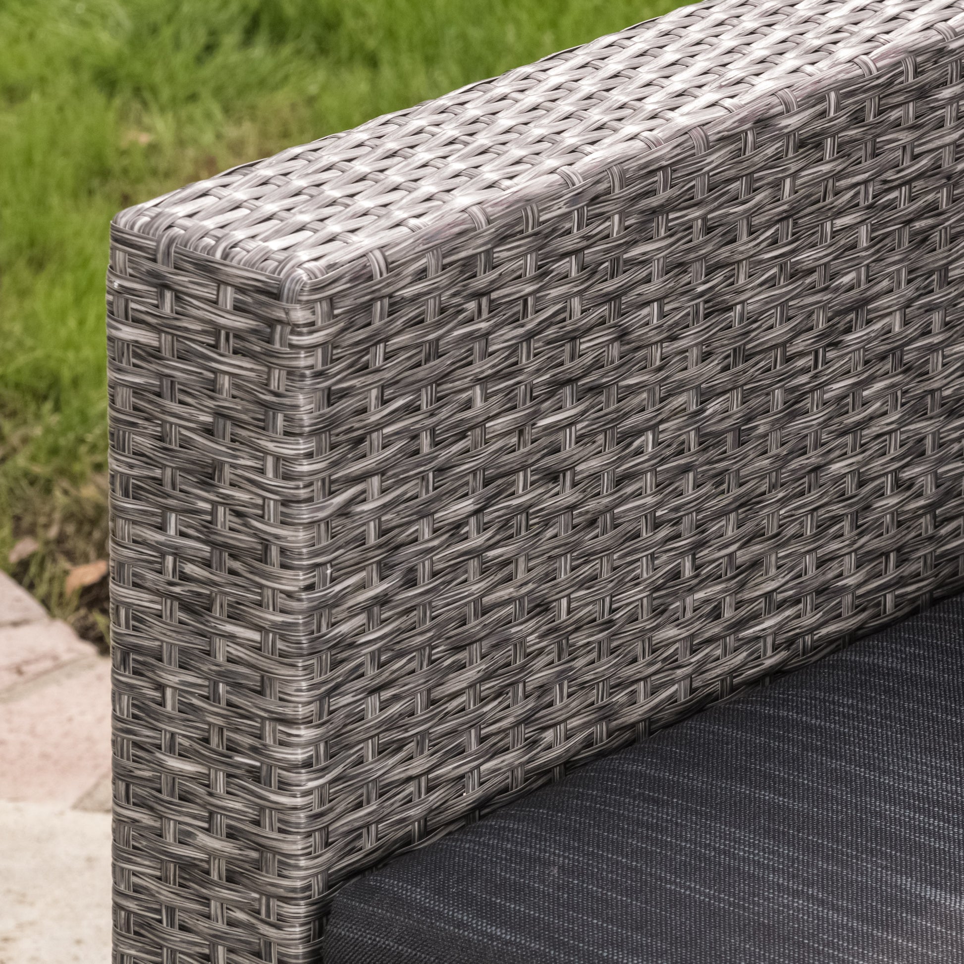 Gray wicker chair armrest with dark gray cushion detail