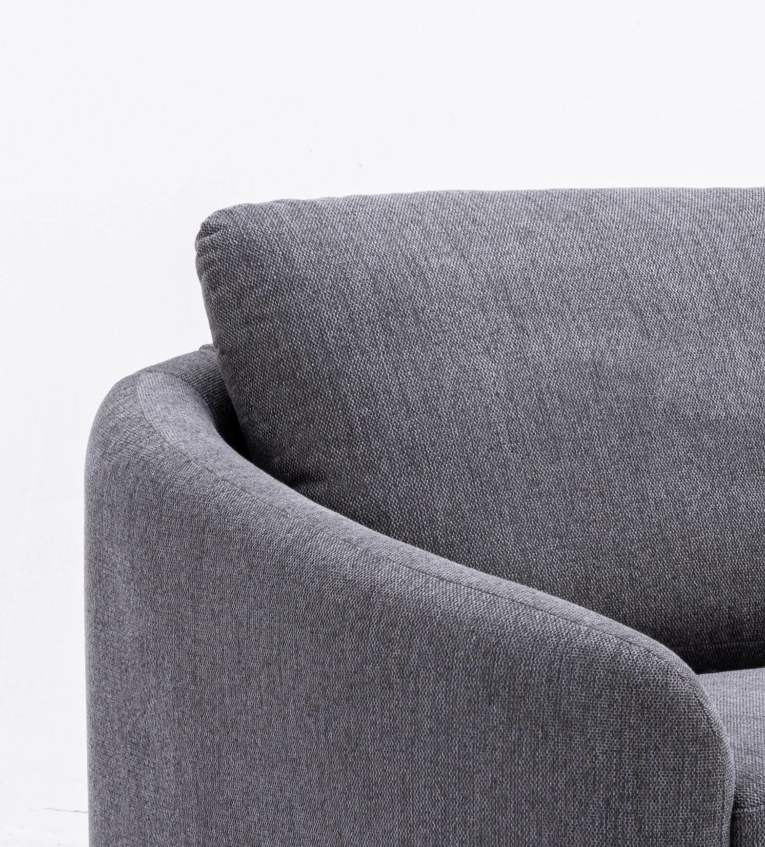 Closeup of a gray upholstered sofa arm and cushion with textured fabric