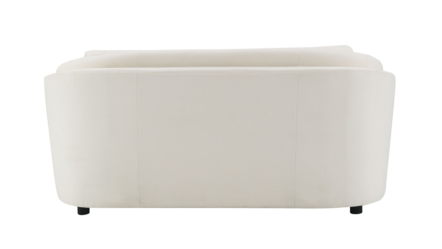 Back view of a plush cream velvet armchair with curved lines and black legs