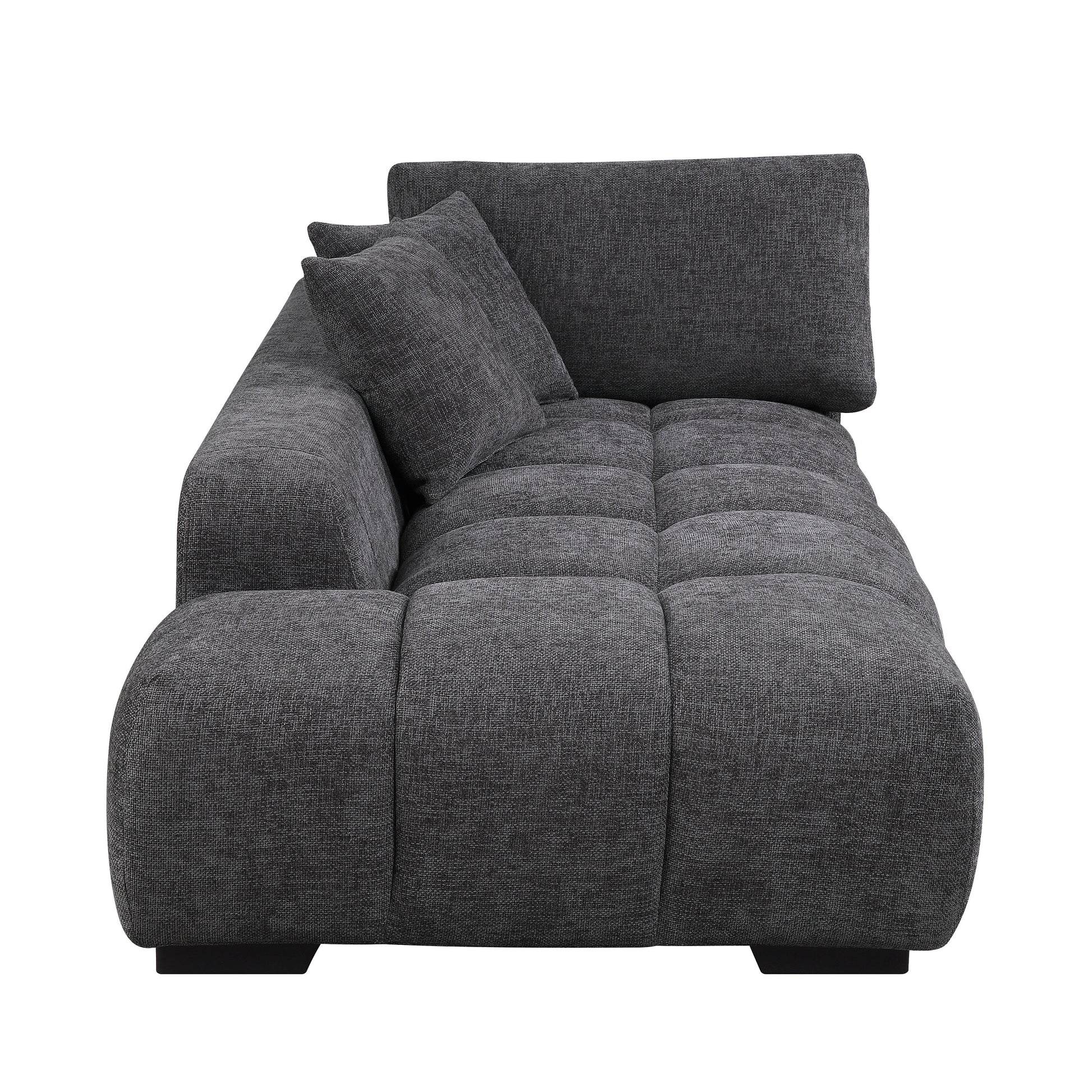 Dark grey fabric sectional sofa with tufted seat cushions and two throw pillows
