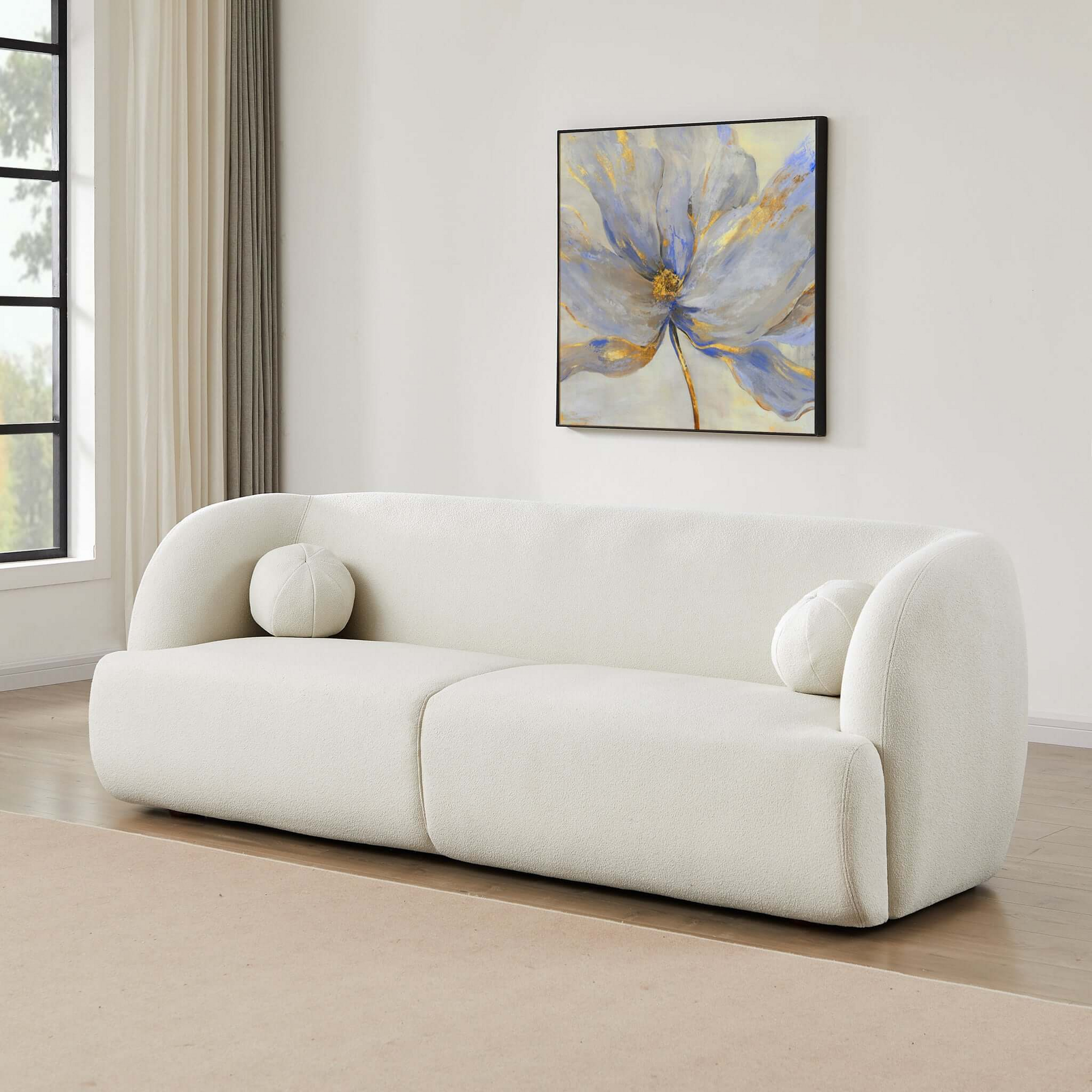 Plush ivory boucle sofa with rounded arms and two accent pillows perfect for modern living rooms