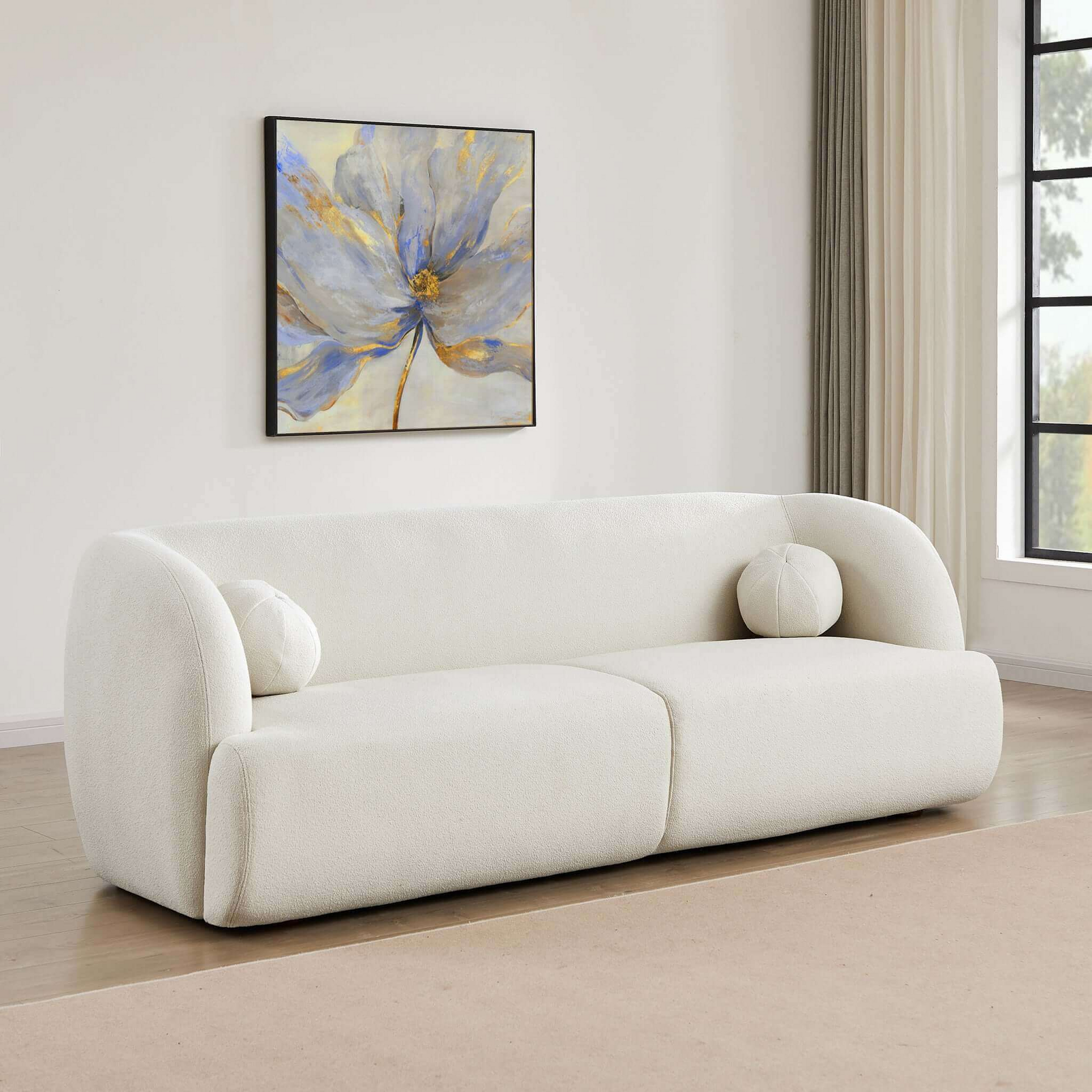 Plush white boucle sofa with rounded arms and two circular accent pillows perfect for modern living rooms