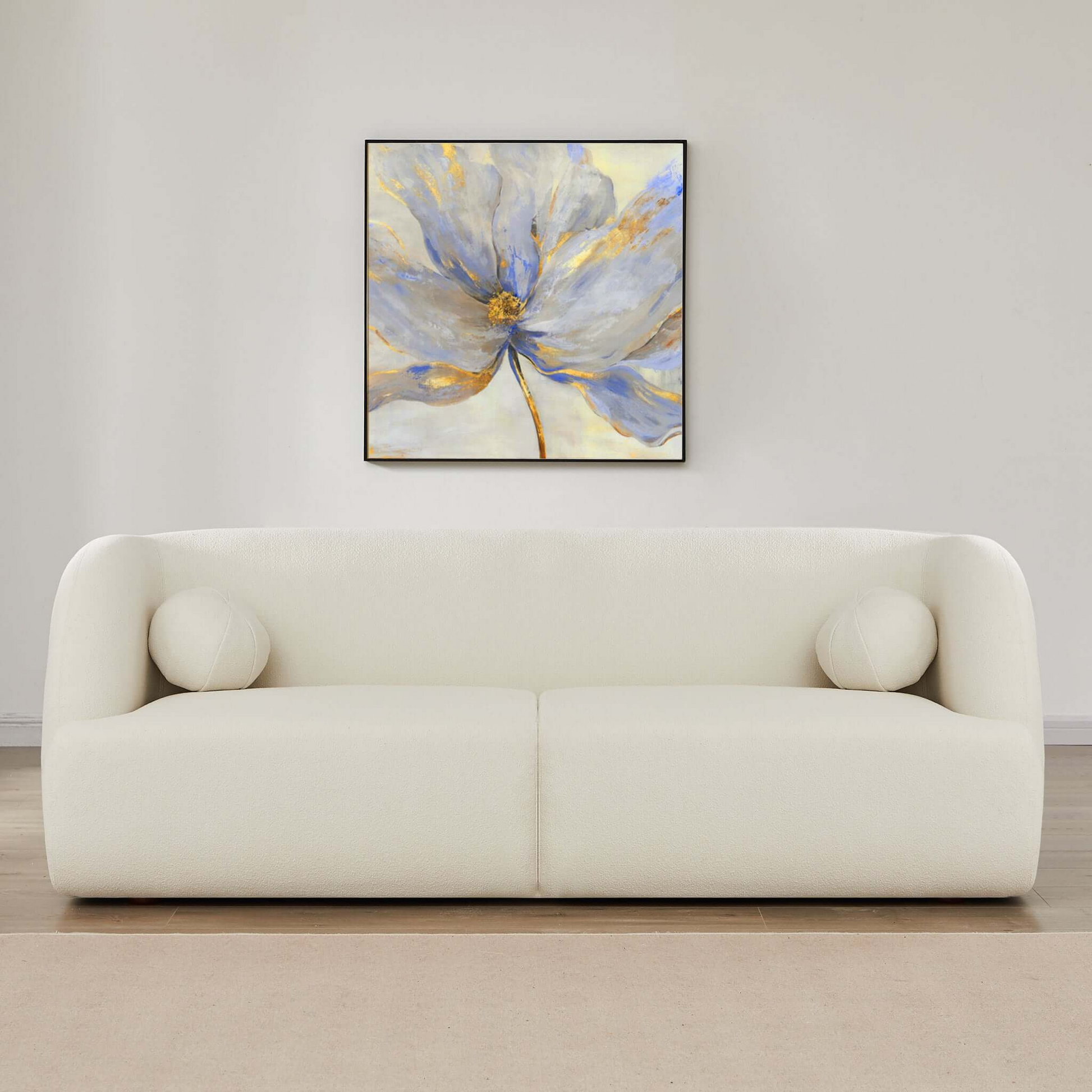 Cream boucle sofa with rounded arms and two circular accent pillows modern design