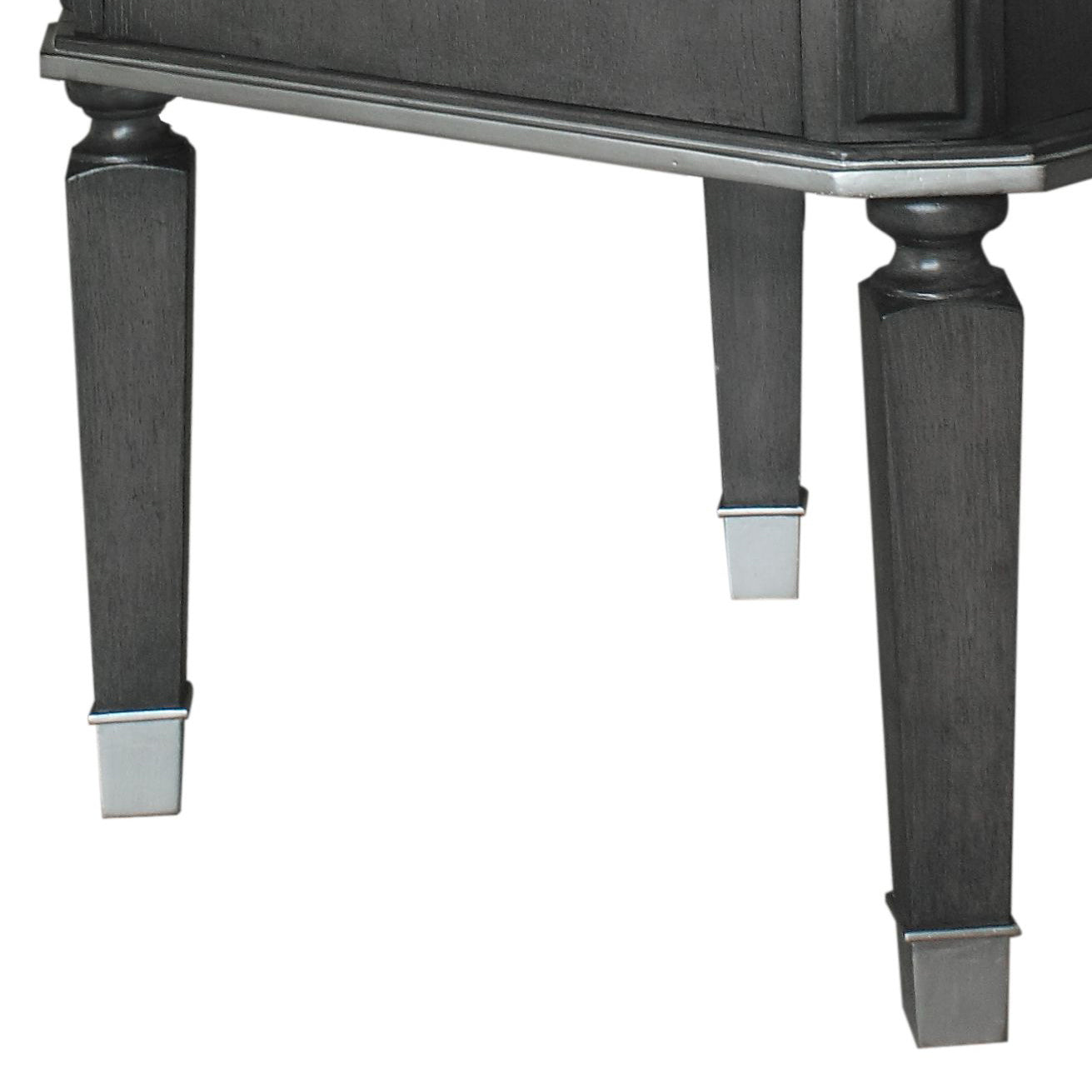 Dark gray wooden furniture legs with silver caps close up view of table base