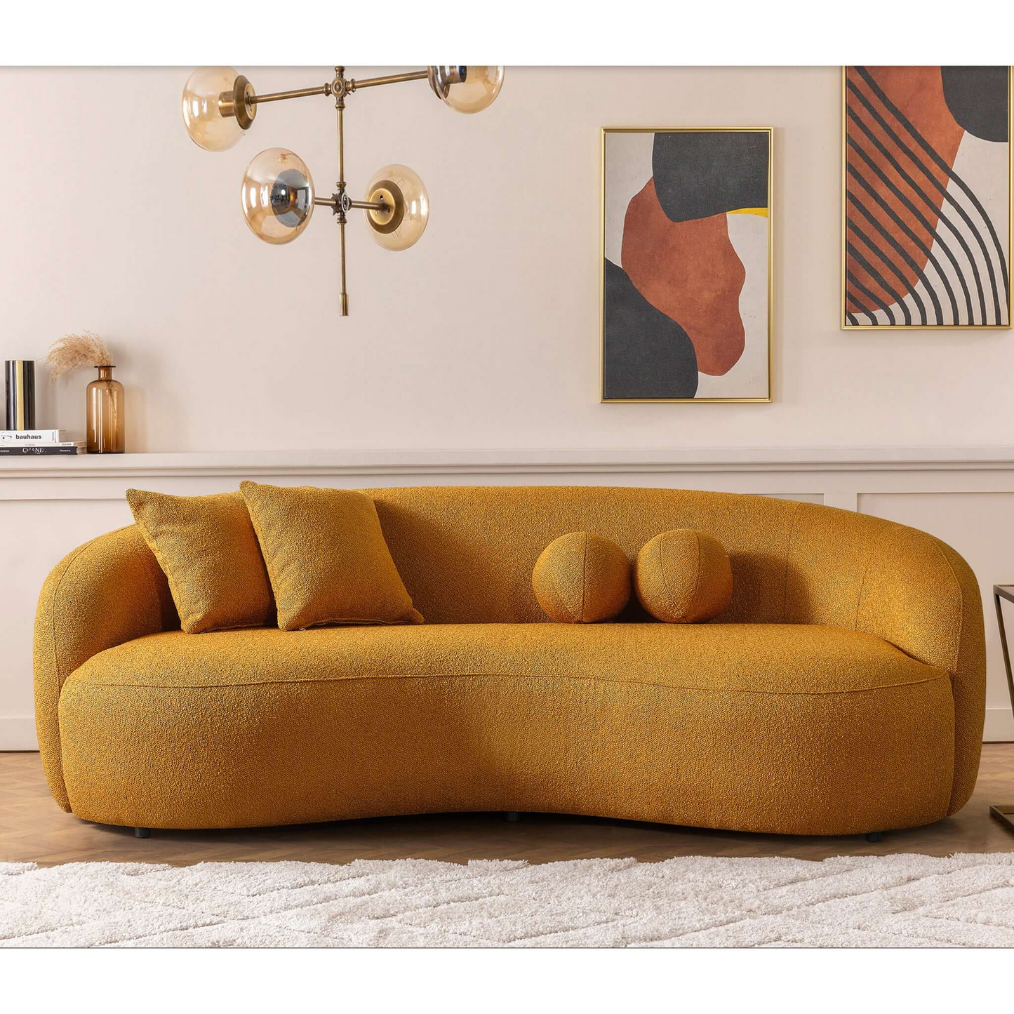 Modern mustard yellow boucle sofa with curved silhouette and two accent pillows