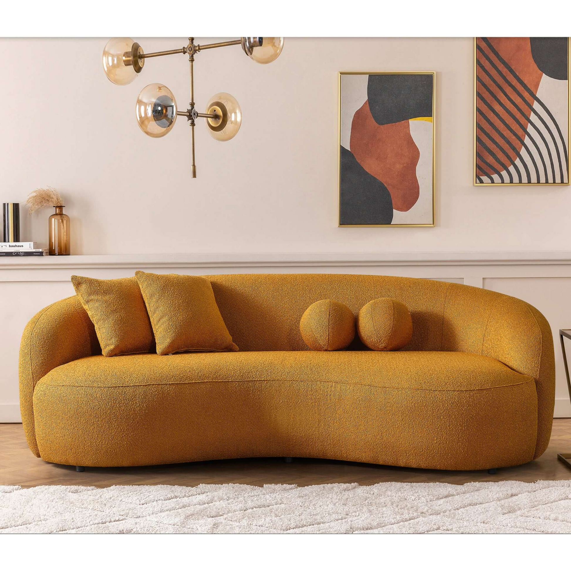 Modern mustard yellow boucle sofa with curved silhouette and two accent pillows