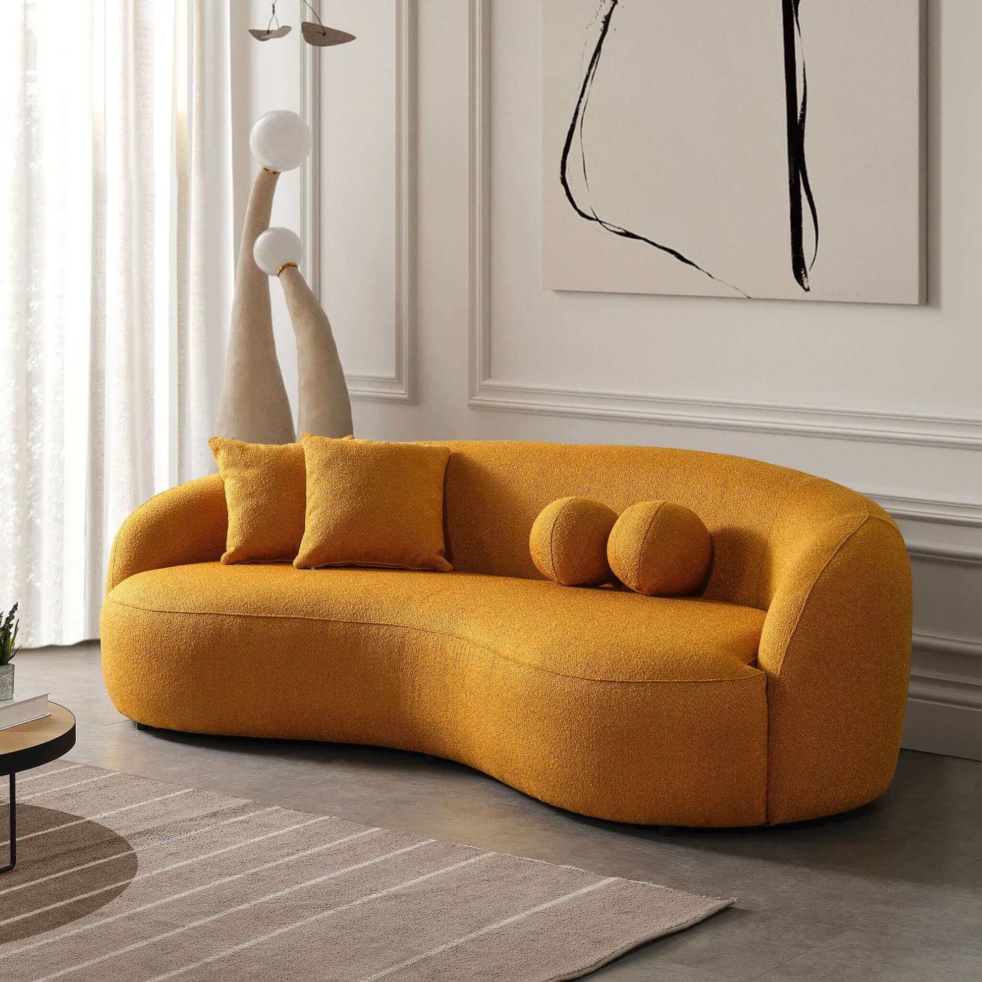 Curved ochre boucle fabric sofa with two square and two round pillows modern living room seating