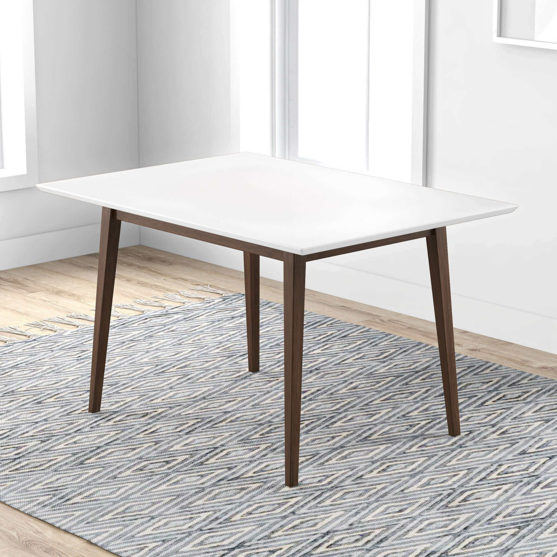 Modern white dining table with dark wood legs on a patterned rug