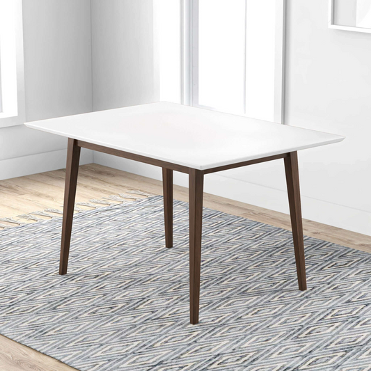 Modern white dining table with dark wood legs on a patterned rug