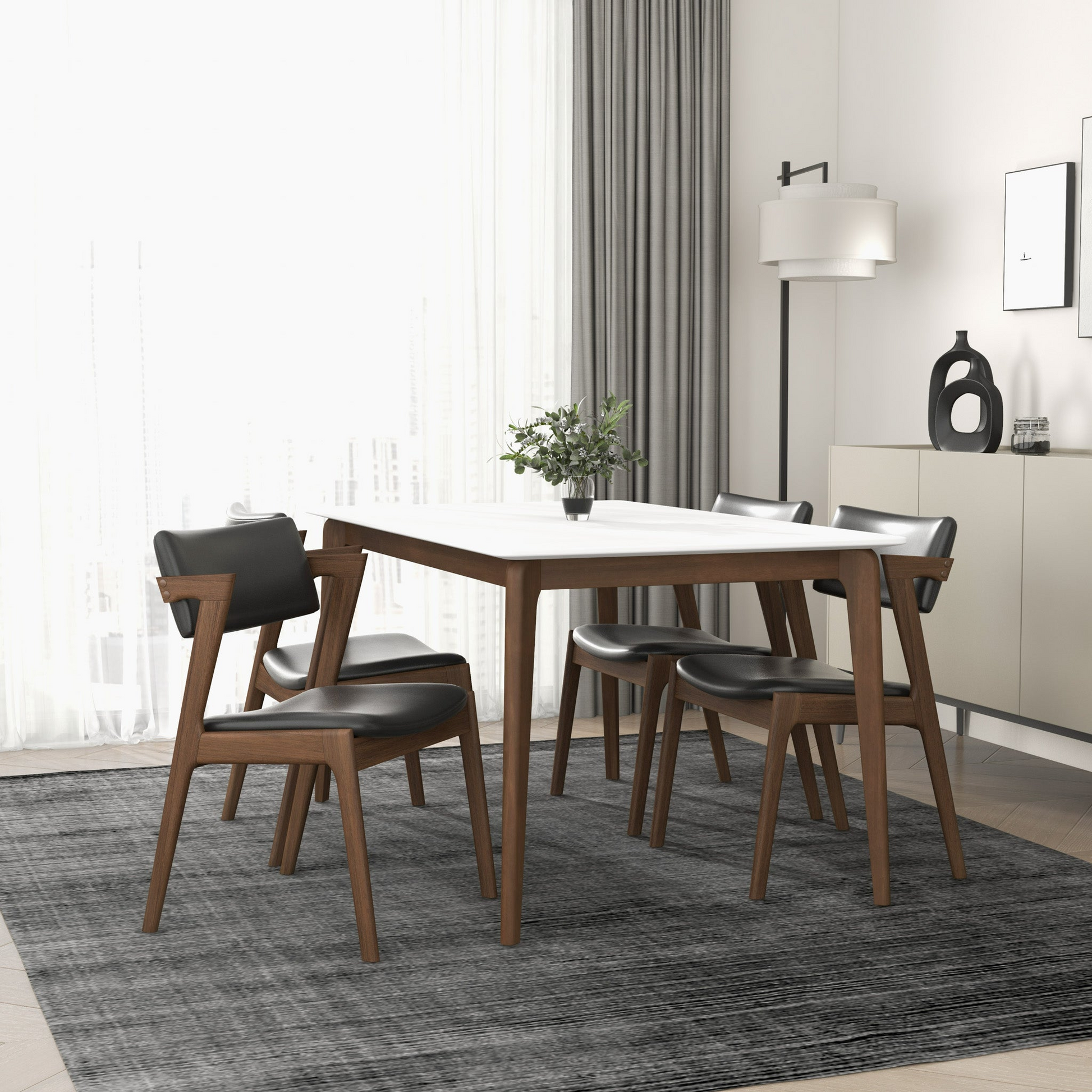 Modern white dining table with sleek black chairs and walnut wood legs