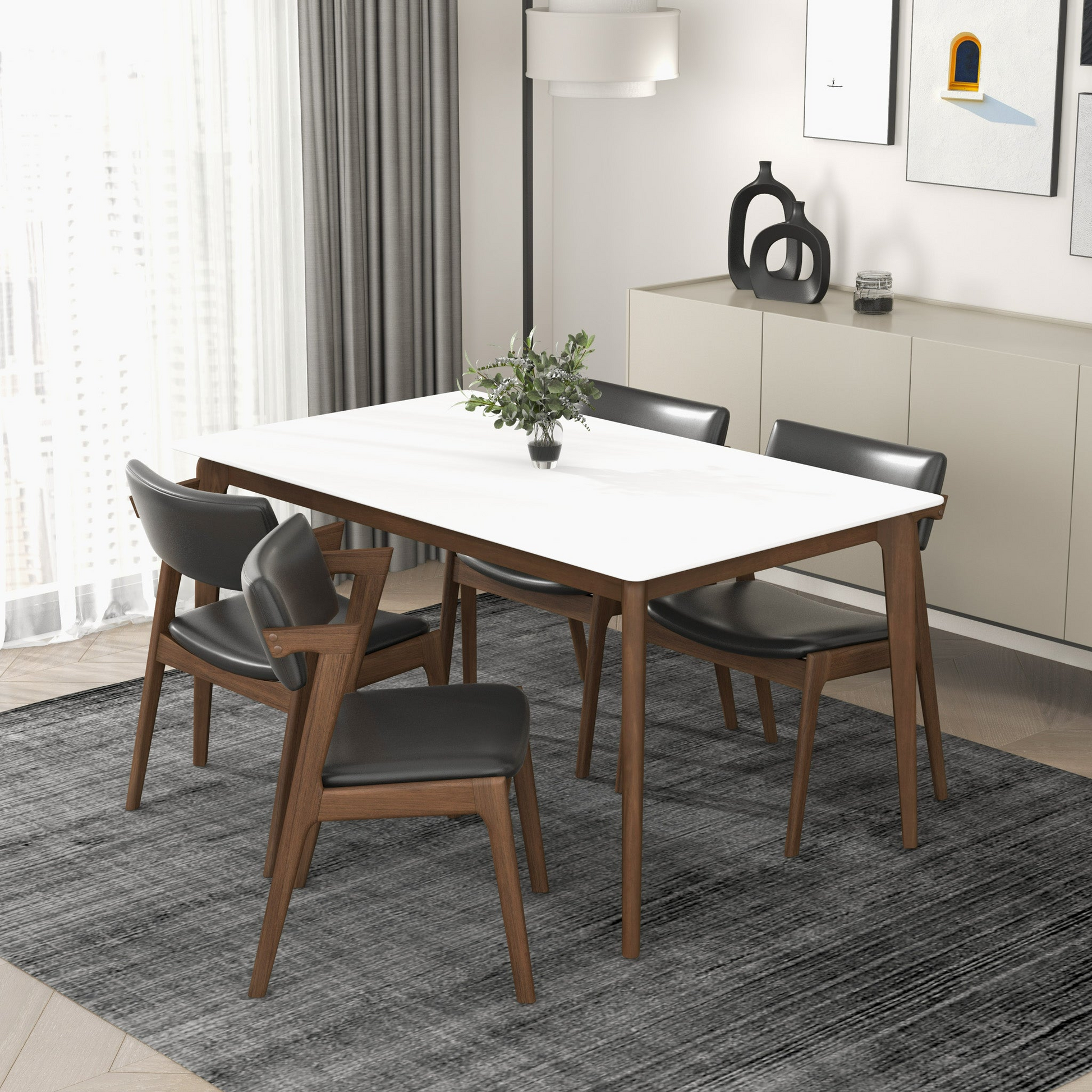 White marble top dining table with dark wood legs and four black leather chairs