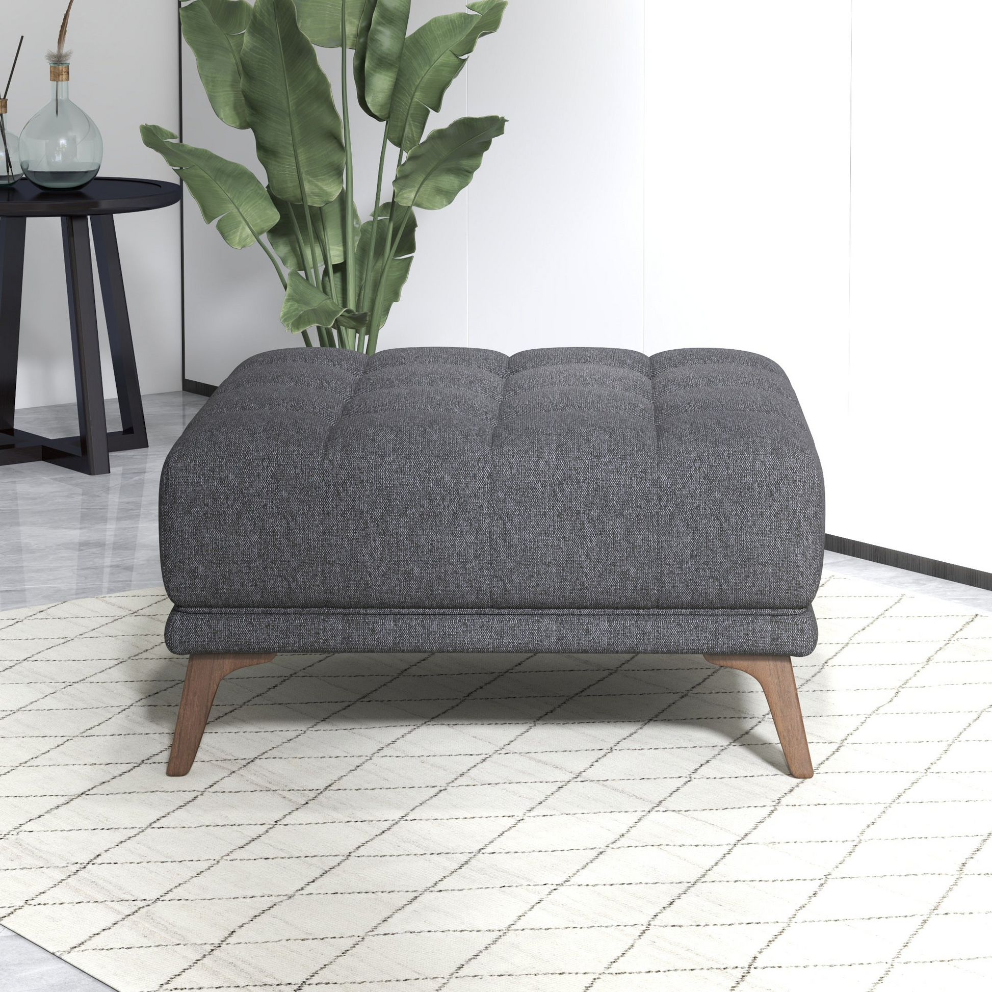 Tufted grey fabric ottoman with angled wooden legs perfect for living room seating
