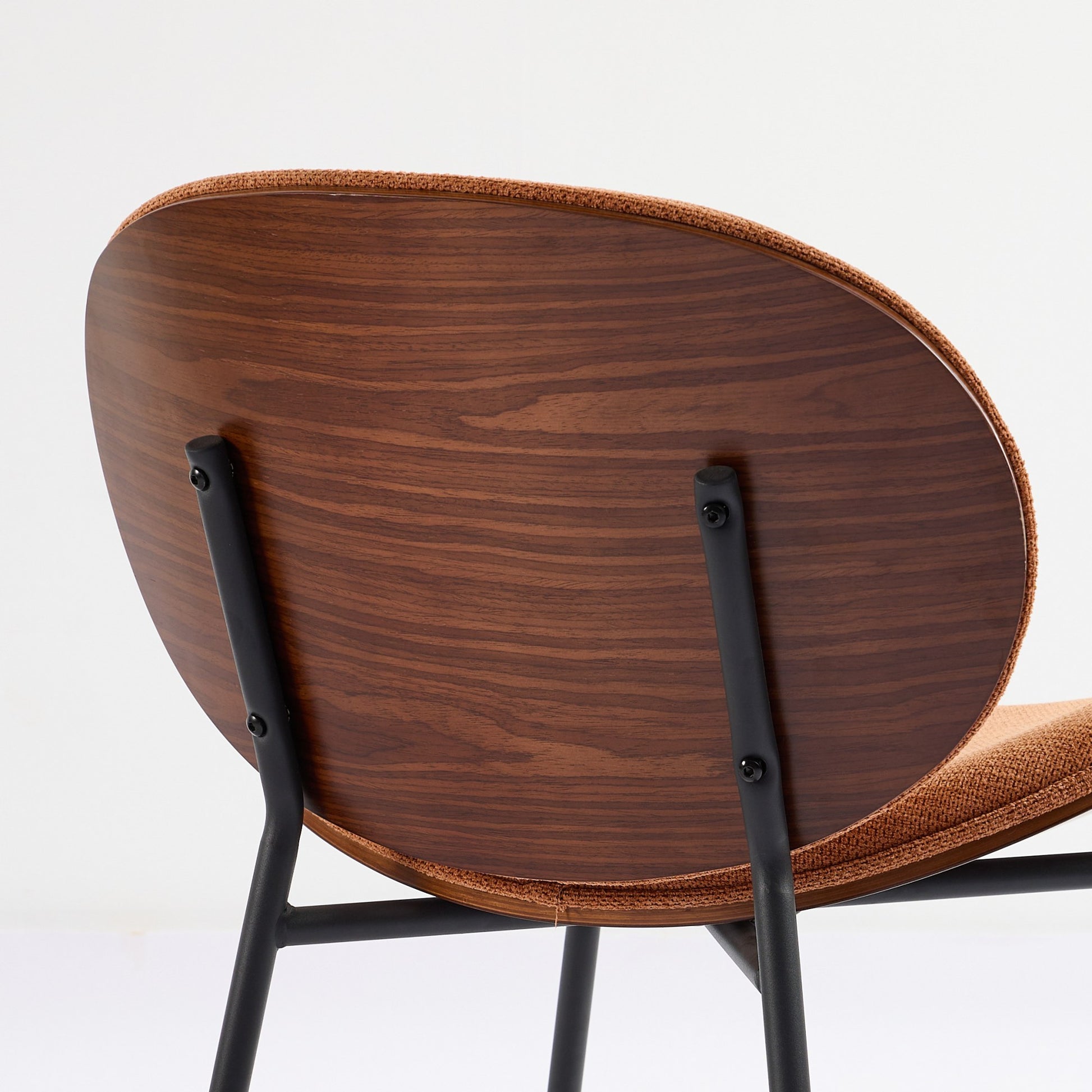 Back of midcentury modern armchair with walnut veneer and orange boucle upholstery