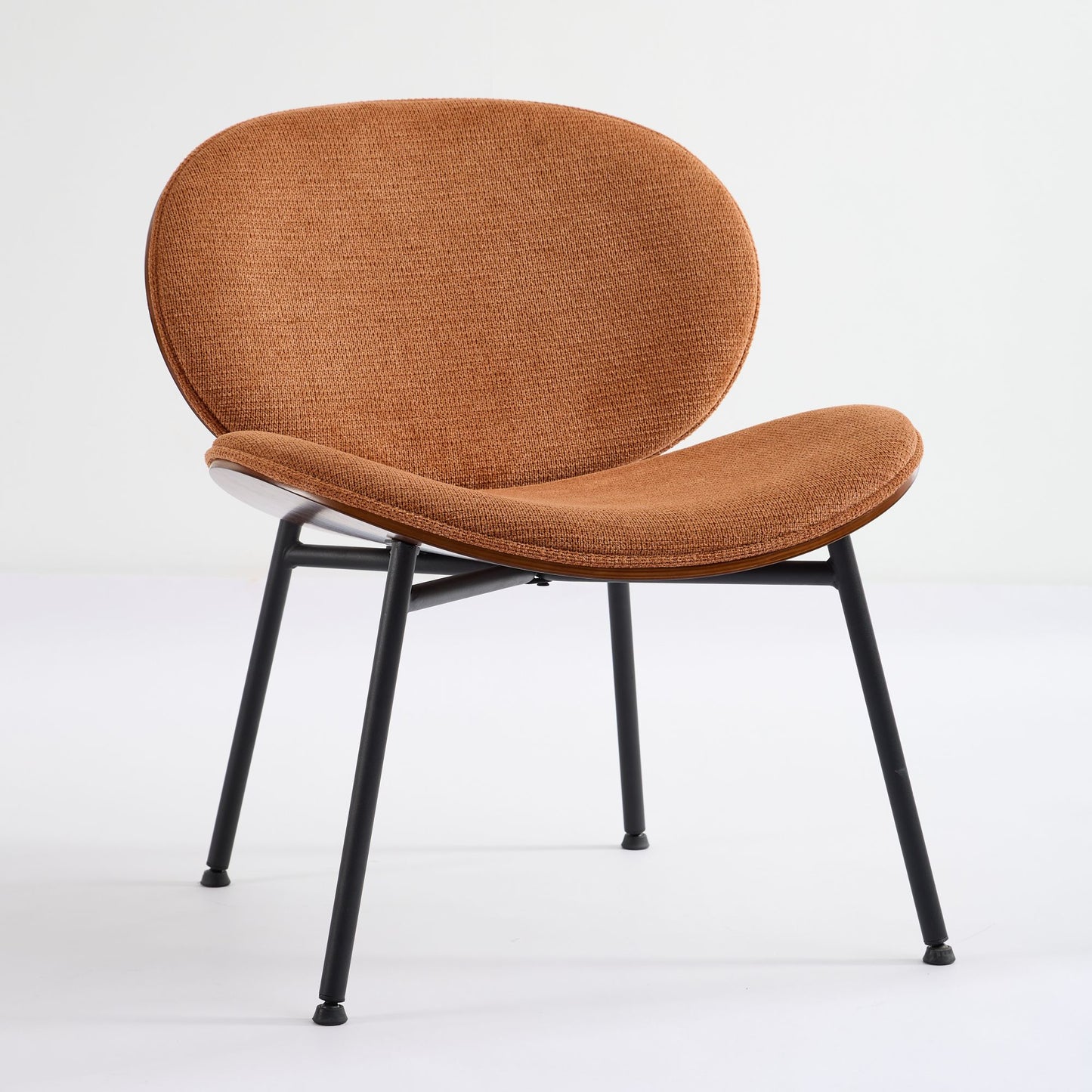 Curved burnt orange upholstered accent chair with slender black metal legs perfect for modern living rooms