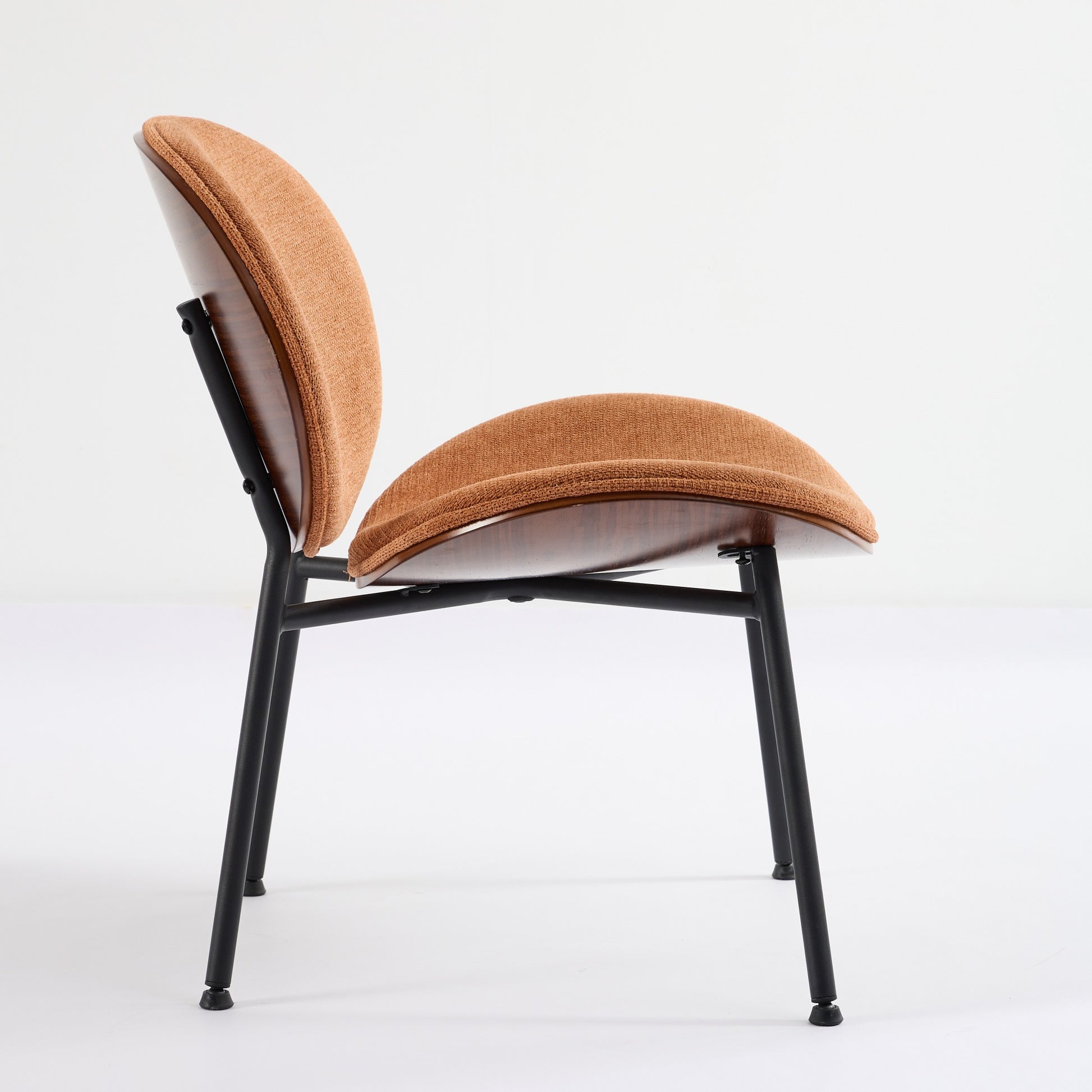 Modern armchair in textured burnt orange fabric with dark wood shell and black metal legs