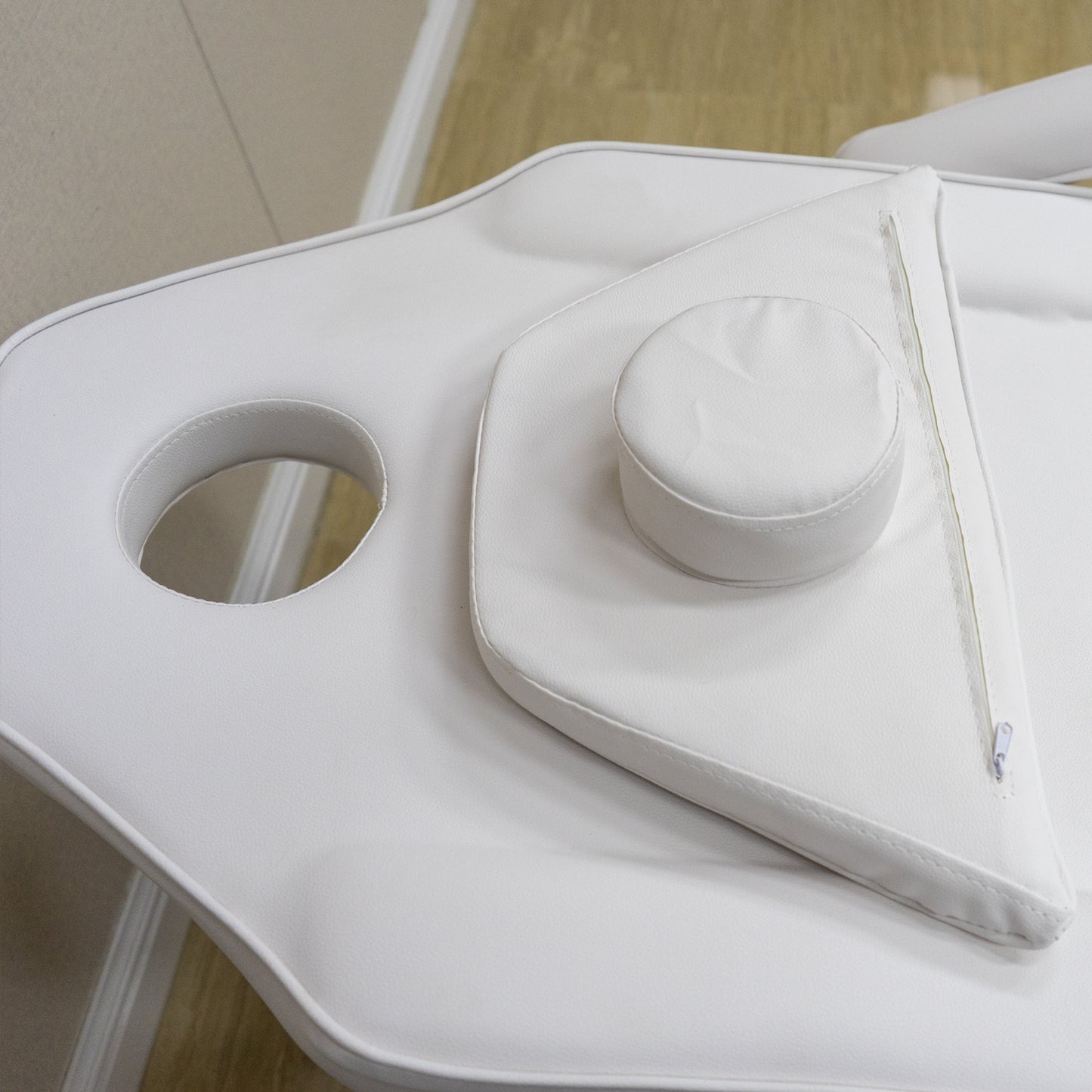 White PU leather massage table with adjustable headrest and face cradle