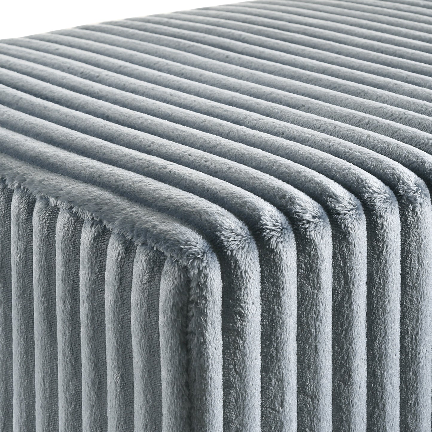 Closeup of plush grey velvet fabric with vertical channel tufting for a soft ottoman