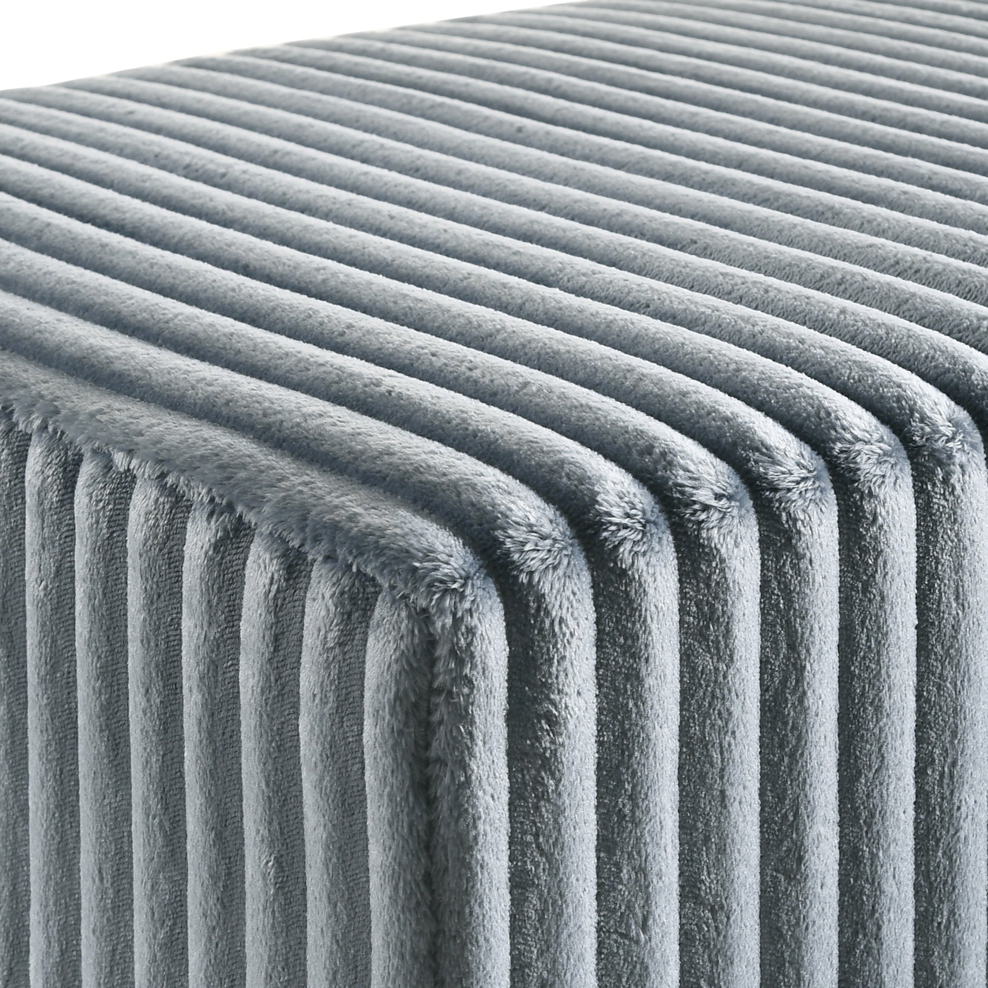 Closeup of plush grey velvet fabric with vertical channel tufting for a soft ottoman