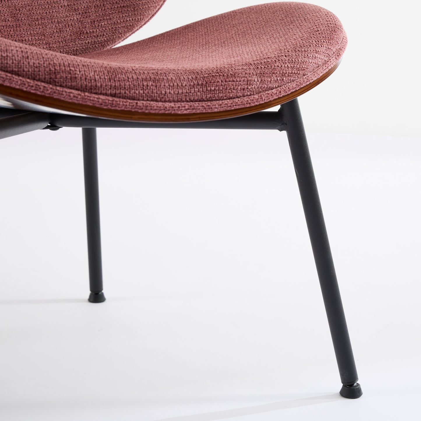 Upholstered dining chair with pink textured fabric and matte black metal legs
