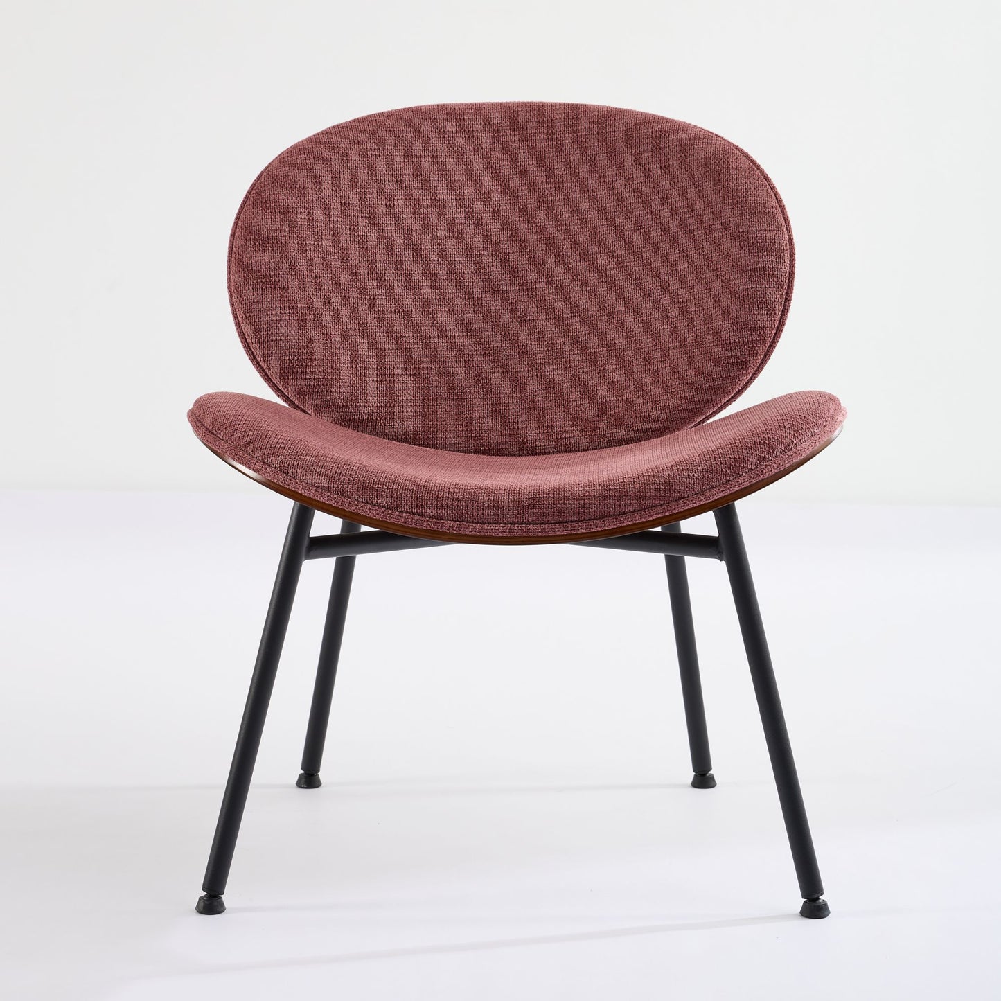 Upholstered dining chair in rose fabric with a curved back and black metal legs