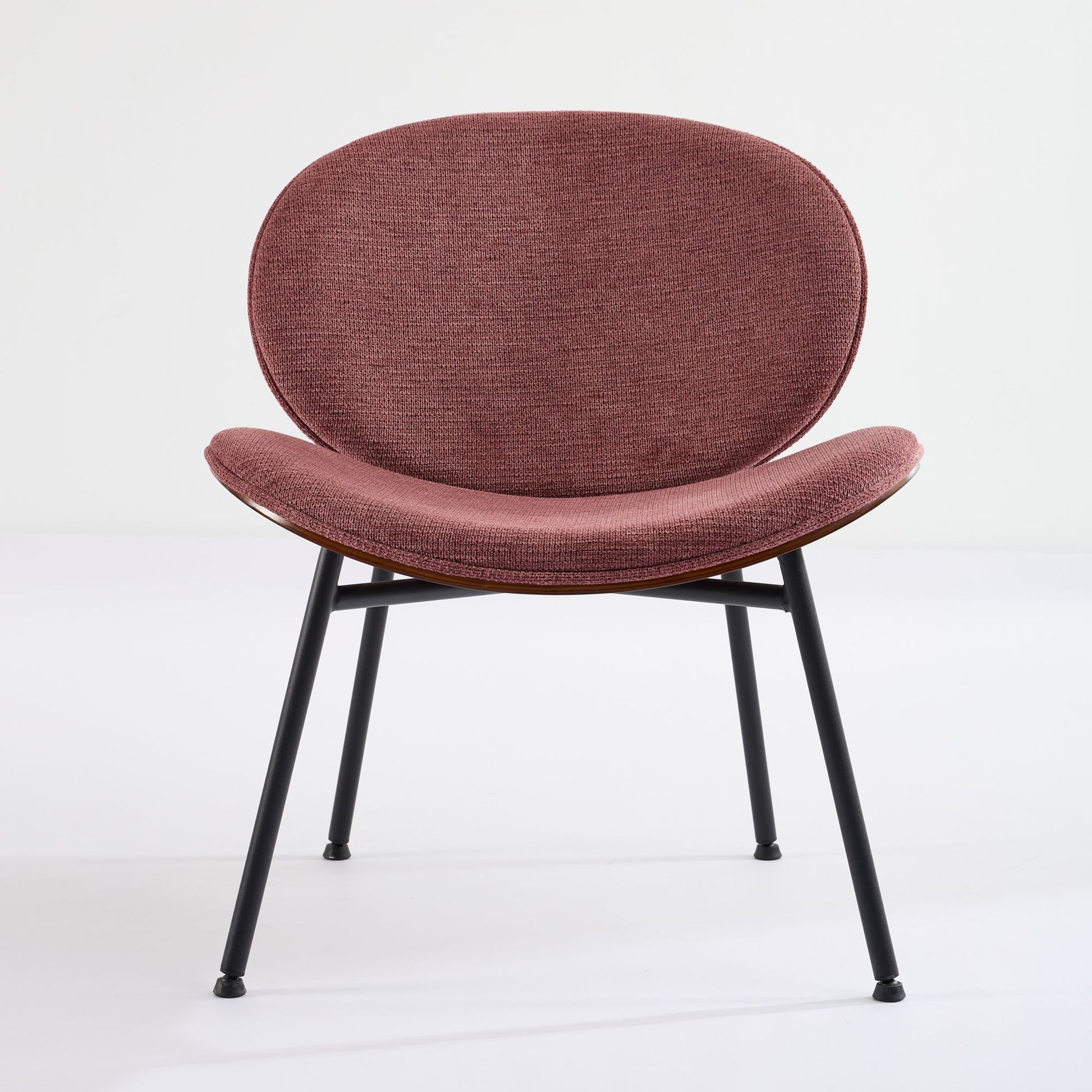 Upholstered dining chair in rose fabric with a curved back and black metal legs