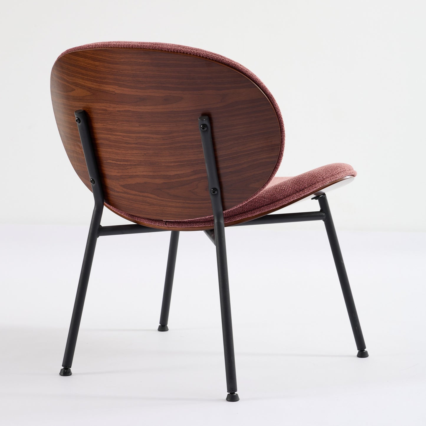 Modern accent chair with curved wood back and rose fabric seat on black metal legs