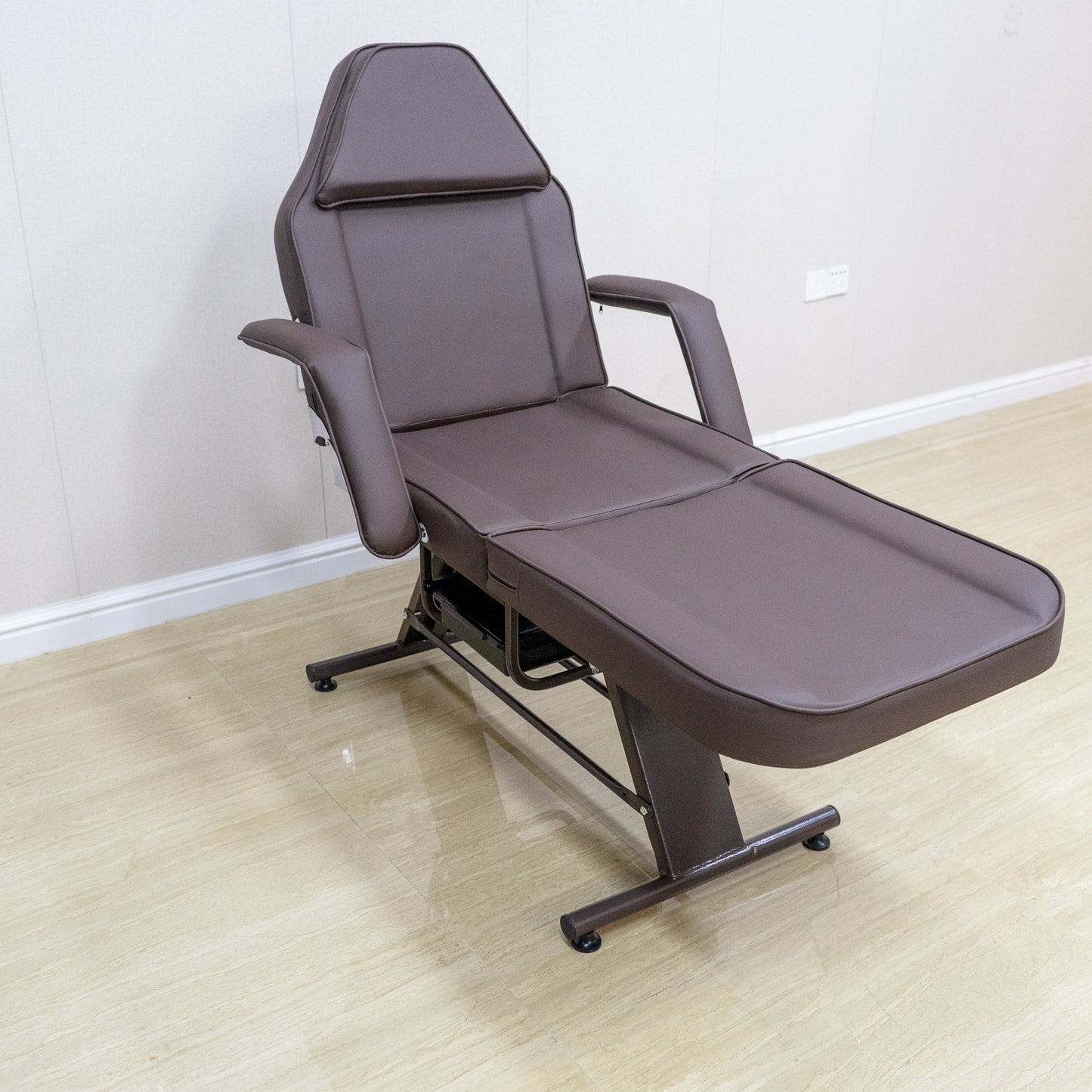 Brown adjustable massage table with padded armrests ideal for spa treatments