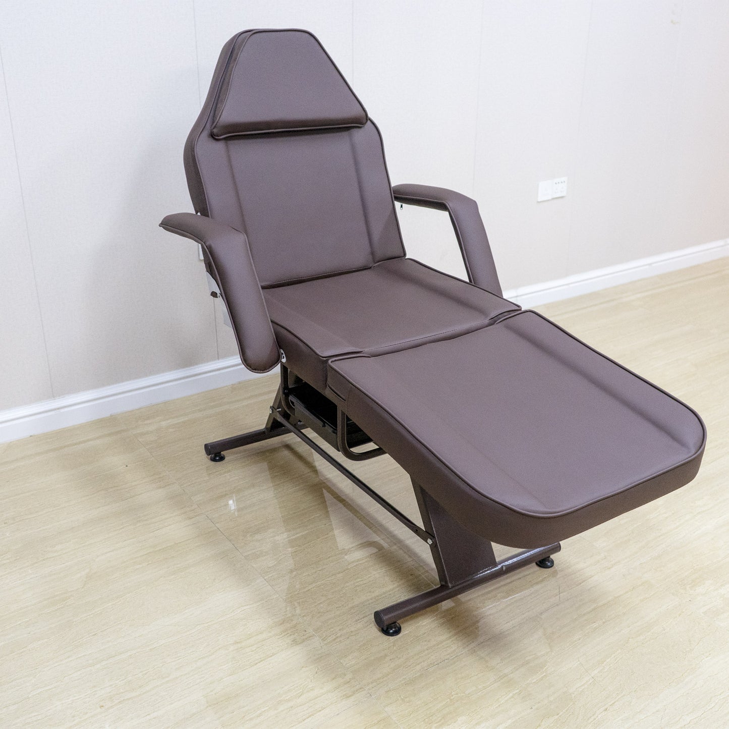 Brown adjustable spa couch with padded headrest and armrests for beauty treatments