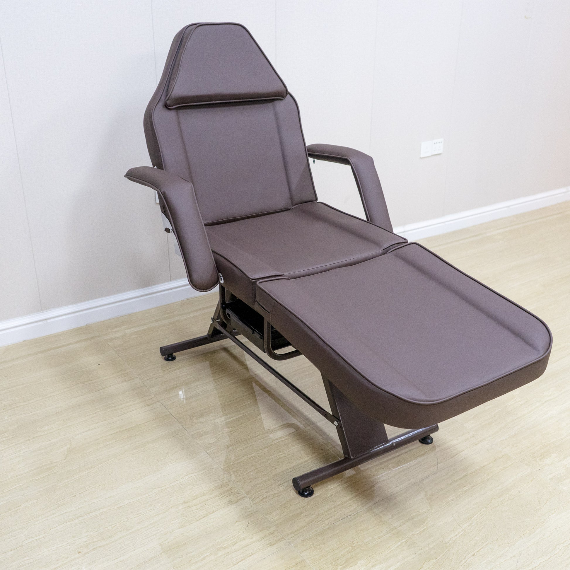 Brown adjustable spa couch with padded headrest and armrests for beauty treatments