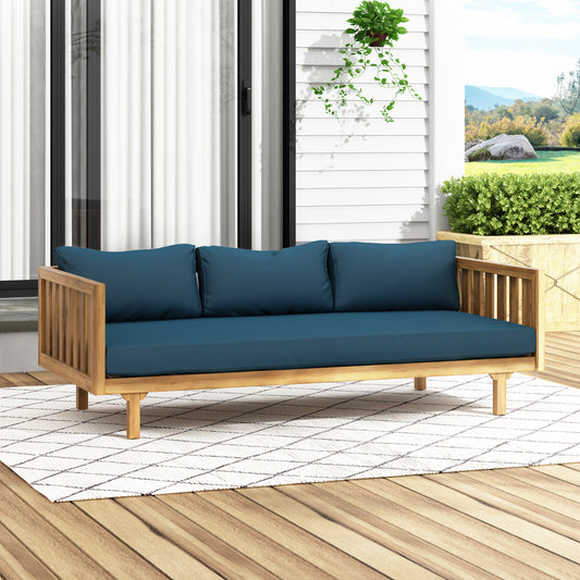 Teak wood outdoor sofa with deep blue cushions and slatted arms on a patterned rug
