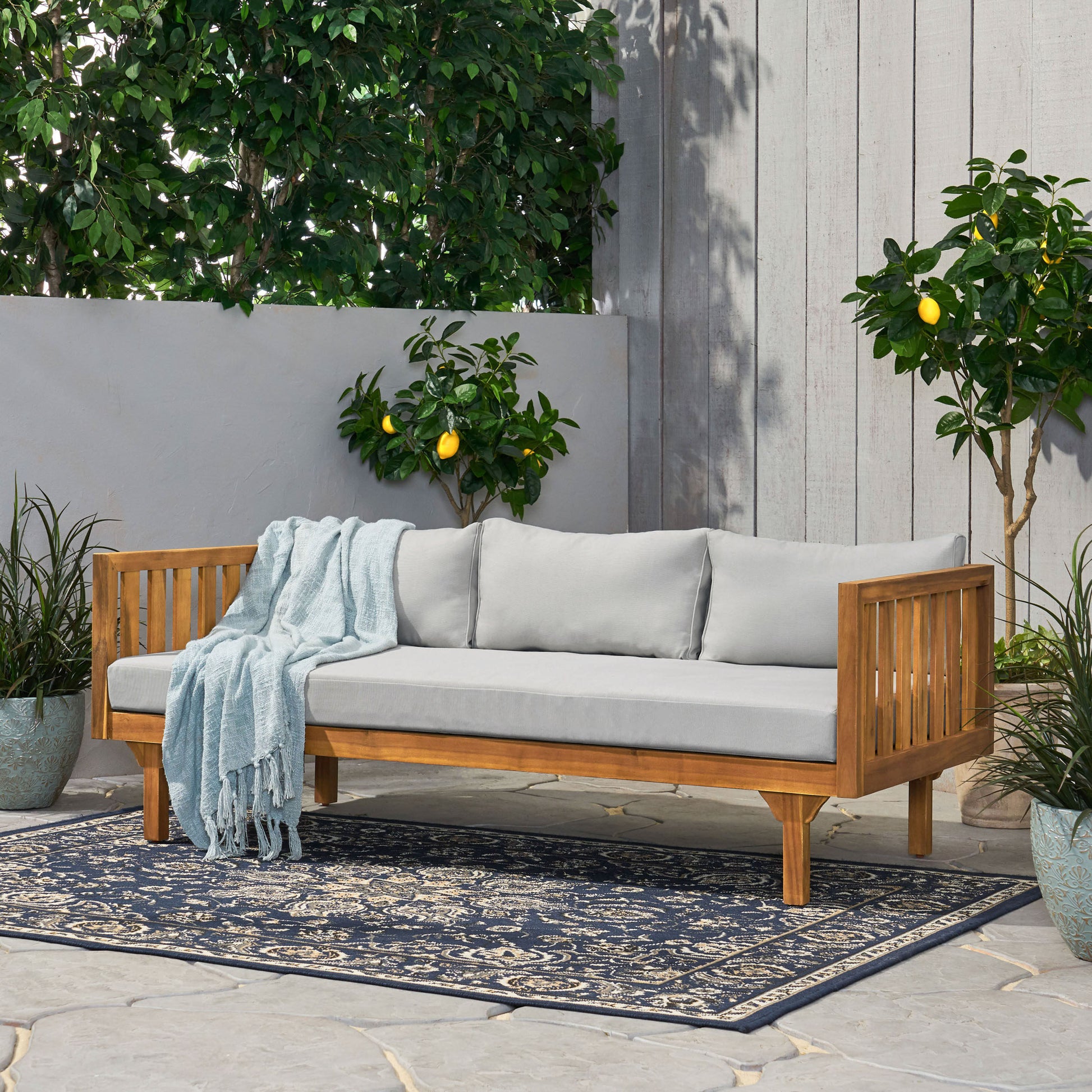 Acacia wood outdoor sofa with light gray cushions perfect for a patio