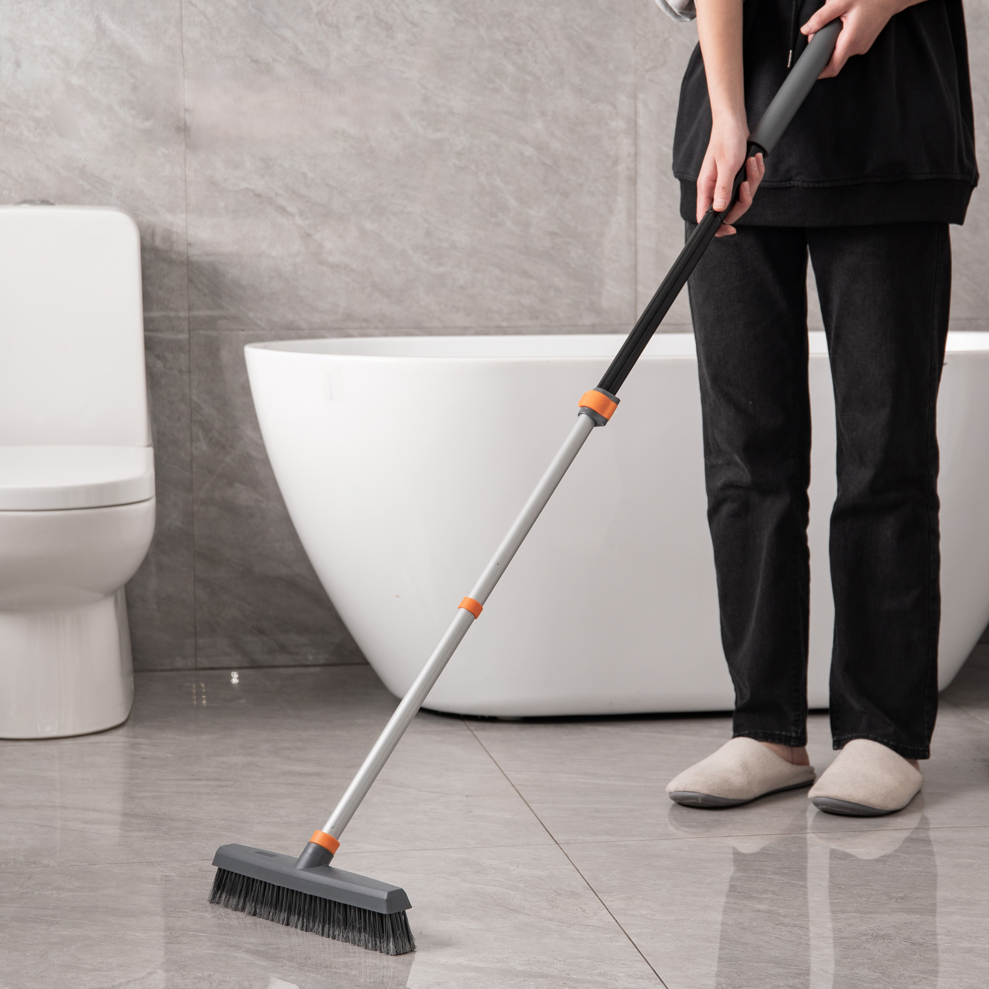 Grey floor scrubbing brush with adjustable long handle for bathroom cleaning