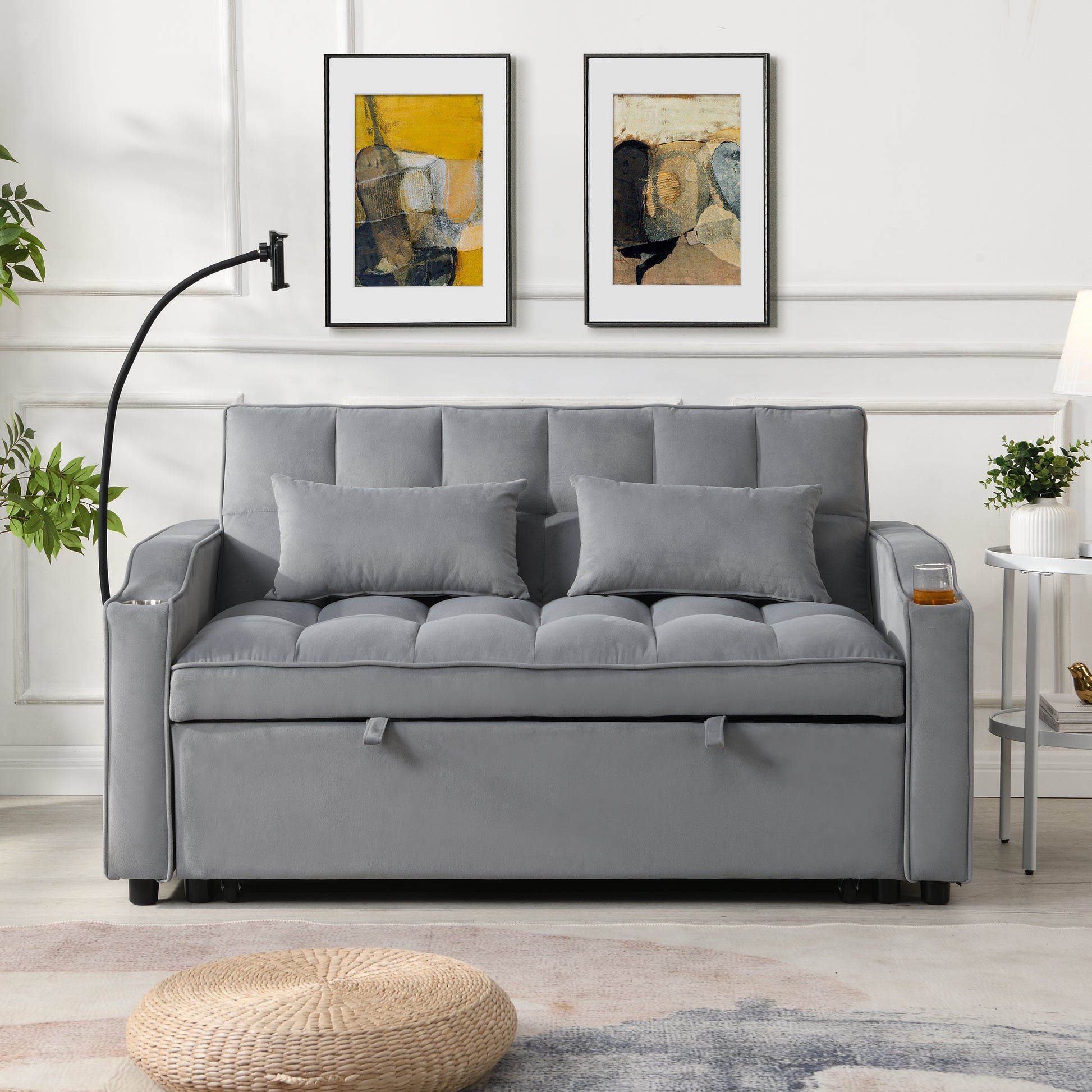 Grey velvet sofa bed with tufted cushions and integrated cup holders