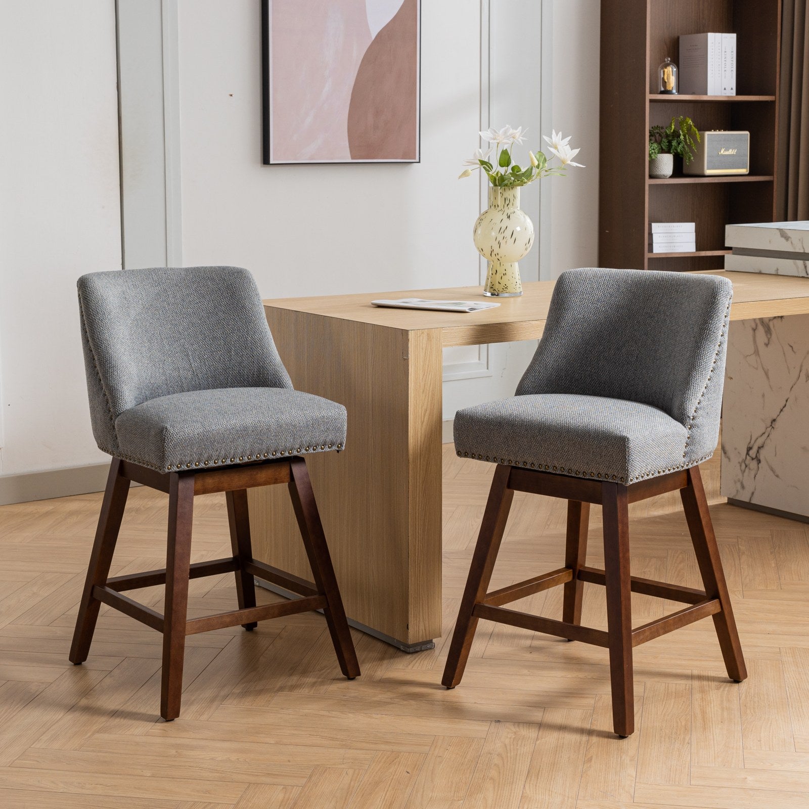 Gray fabric swivel bar stool with nailhead trim and dark wood legs