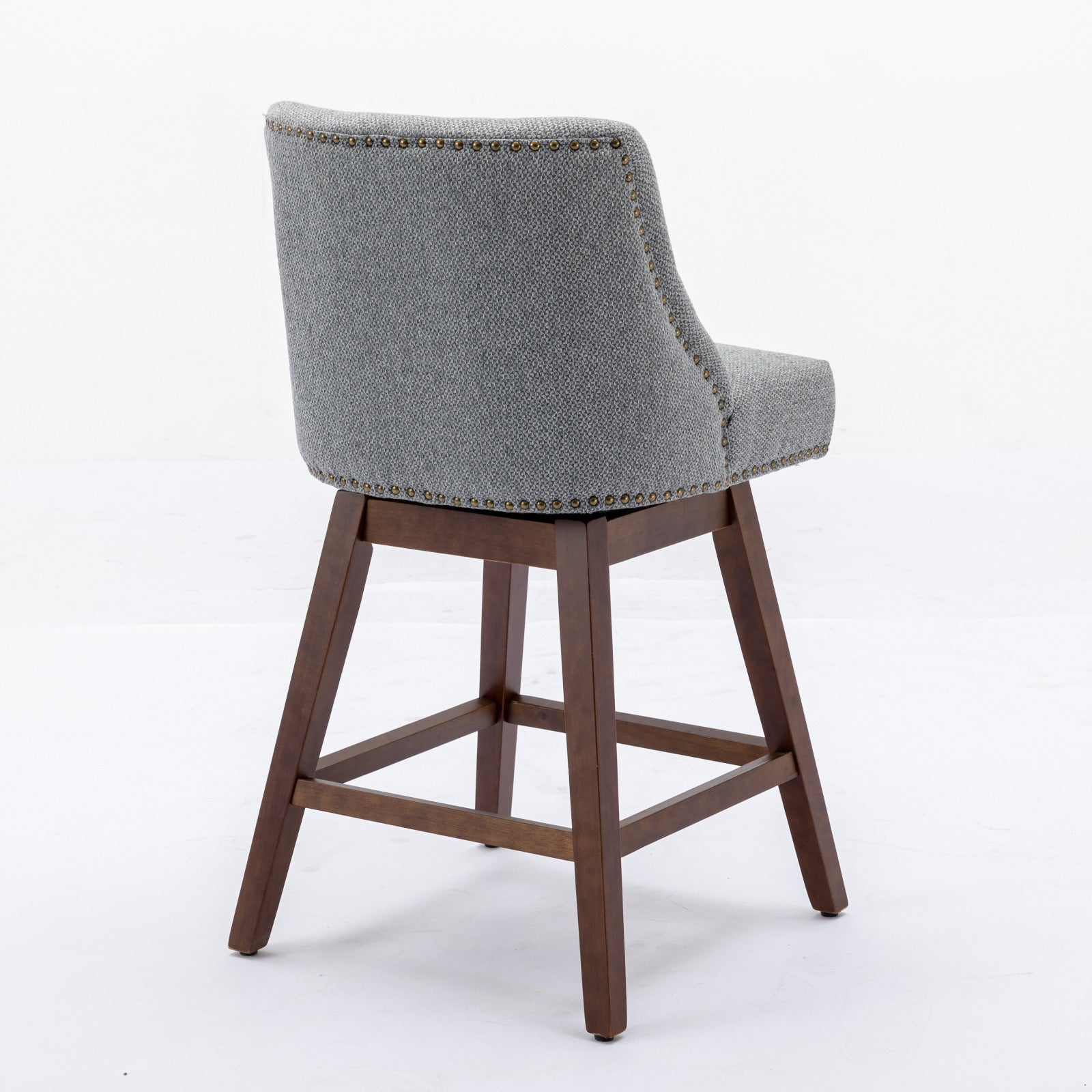Grey upholstered swivel stool with antique brass nailhead trim and wooden legs