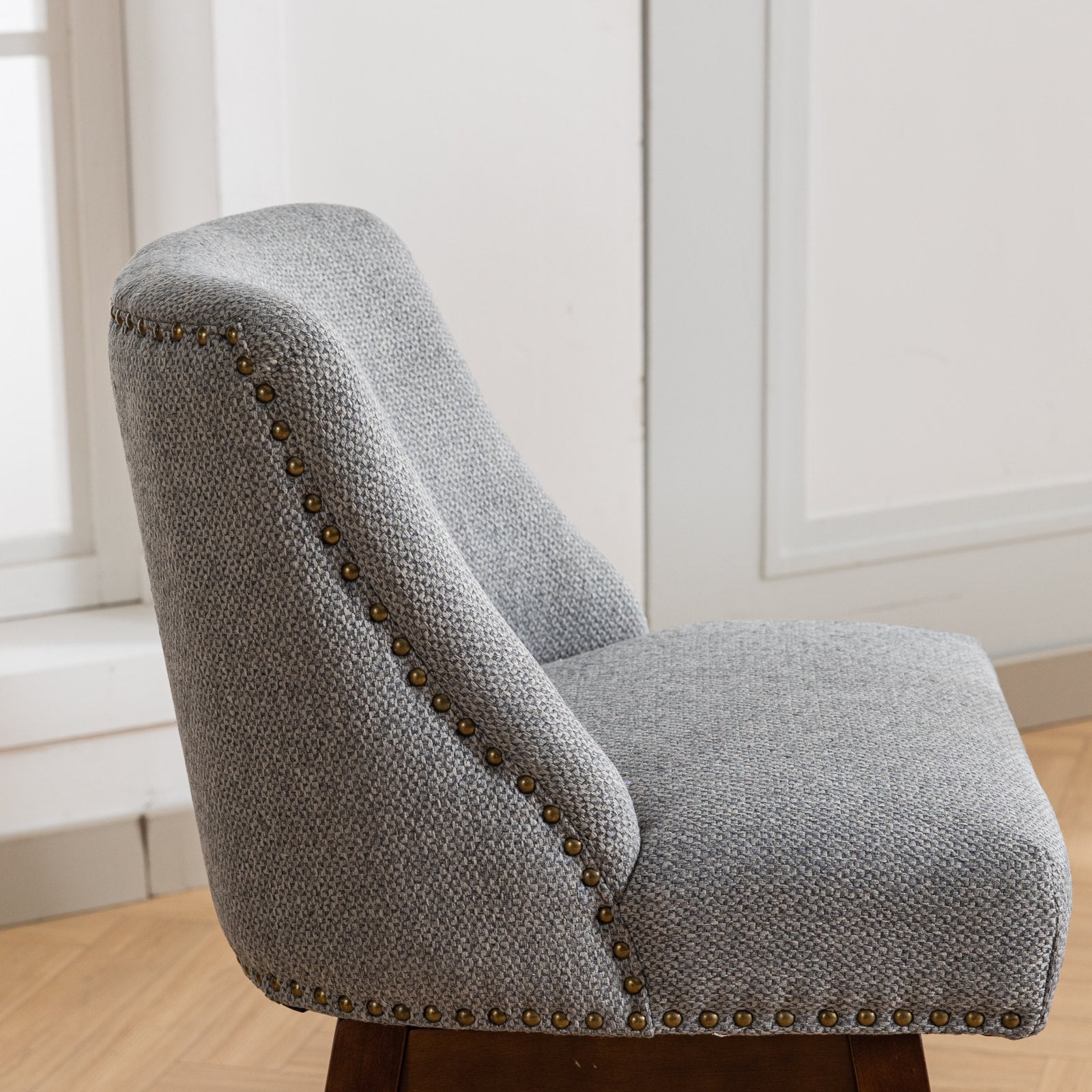 Gray fabric armchair with antique brass nailhead trim perfect for any living room